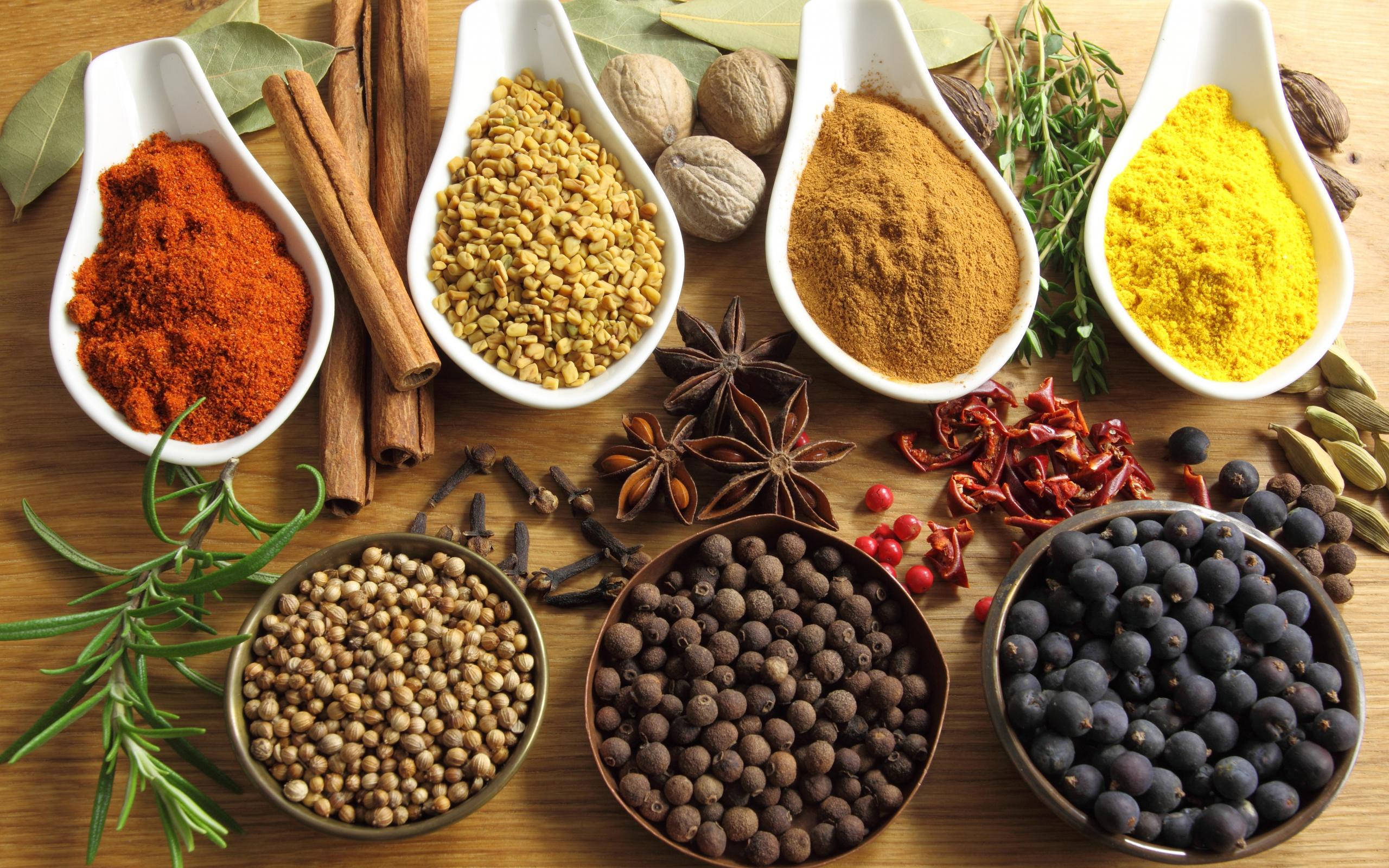 Spices 桌布 壁紙 — 木質表面上白色湯匙和碗中擺放的鮮豔香料和香草。