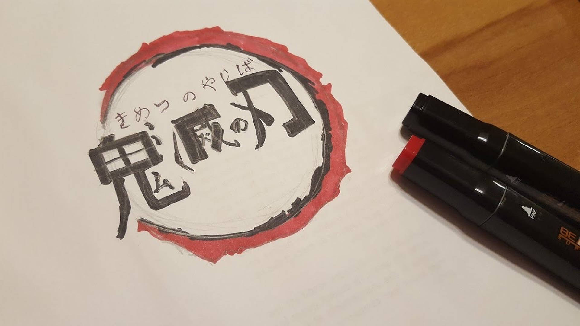鬼滅之刃標誌 桌布 壁紙 — 木質表面上的白紙上，黑色和紅色標記旁邊，手繪日本漢字標誌和紅色墨水圓圈。