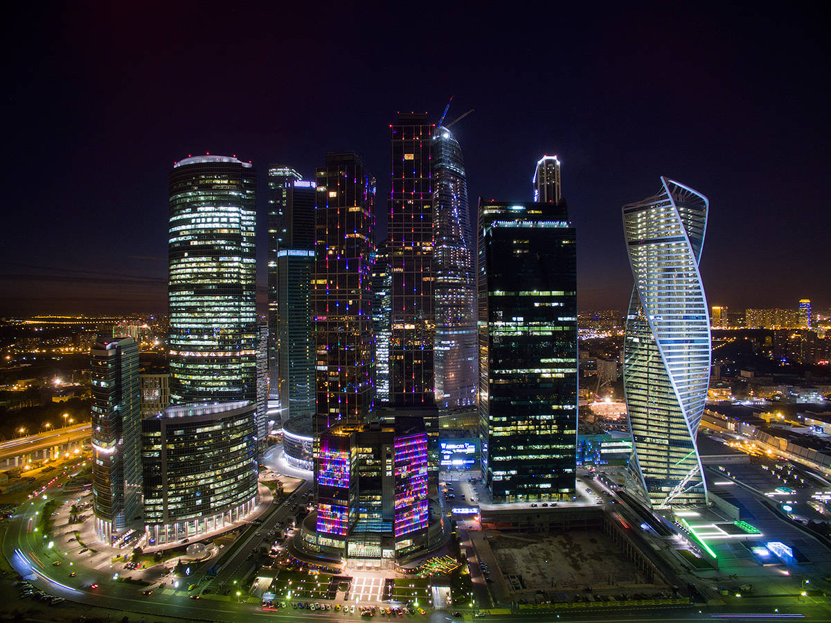 Moscow 桌布 壁紙 — 未來城市景觀的夜間航拍圖，高樓大廈燈火通明，街道閃爍光芒。