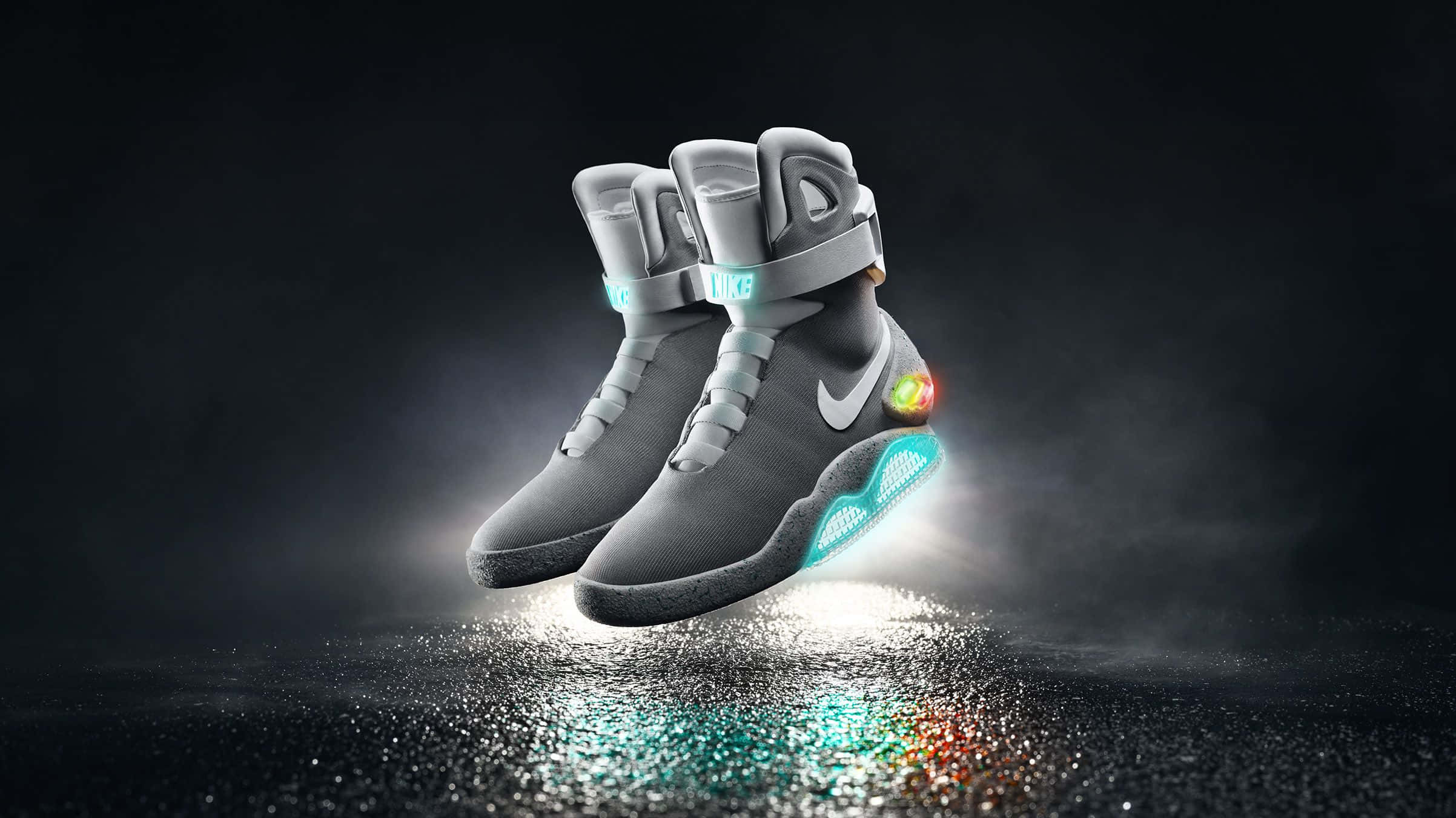 鞋子 桌布 壁紙 — 未來感十足的灰色Nike Mag運動鞋，在黑暗煙霧背景前，於反光的濕滑表面上懸浮，帶有發光的藍色和橙色點綴。