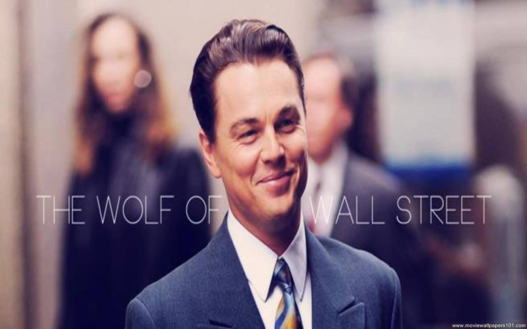 Wolf Of Wall Street 桌布 壁紙 — 李奧納多·狄卡皮歐穿著筆挺西裝，在模糊的辦公室走廊中自信微笑，並帶有電影標題覆蓋層。