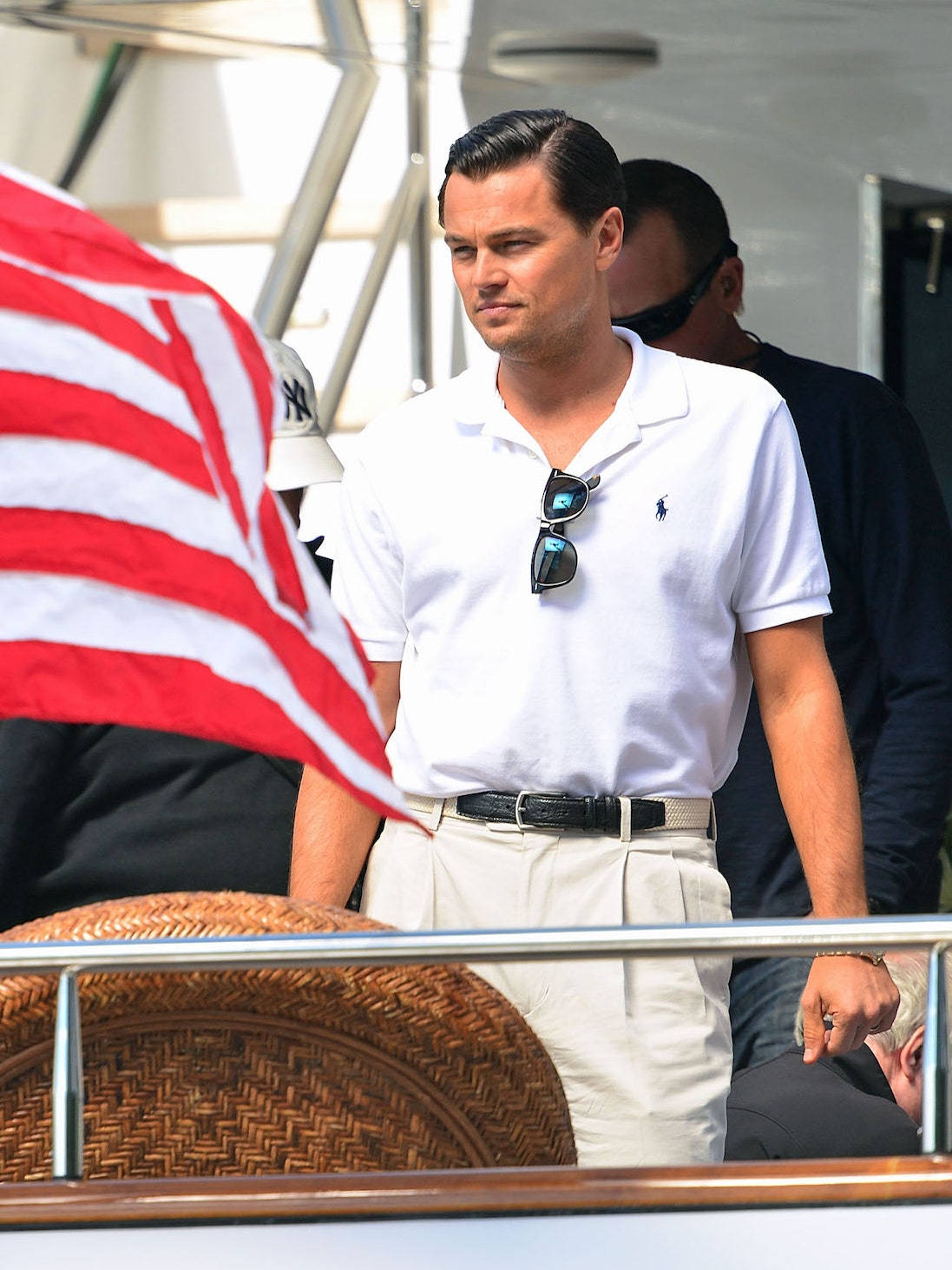 Celebrity 桌布 壁紙 — 李奧納多·狄卡皮歐站在遊艇上，身穿白色Polo衫，衣領掛著太陽眼鏡，附近有美國國旗飄揚。