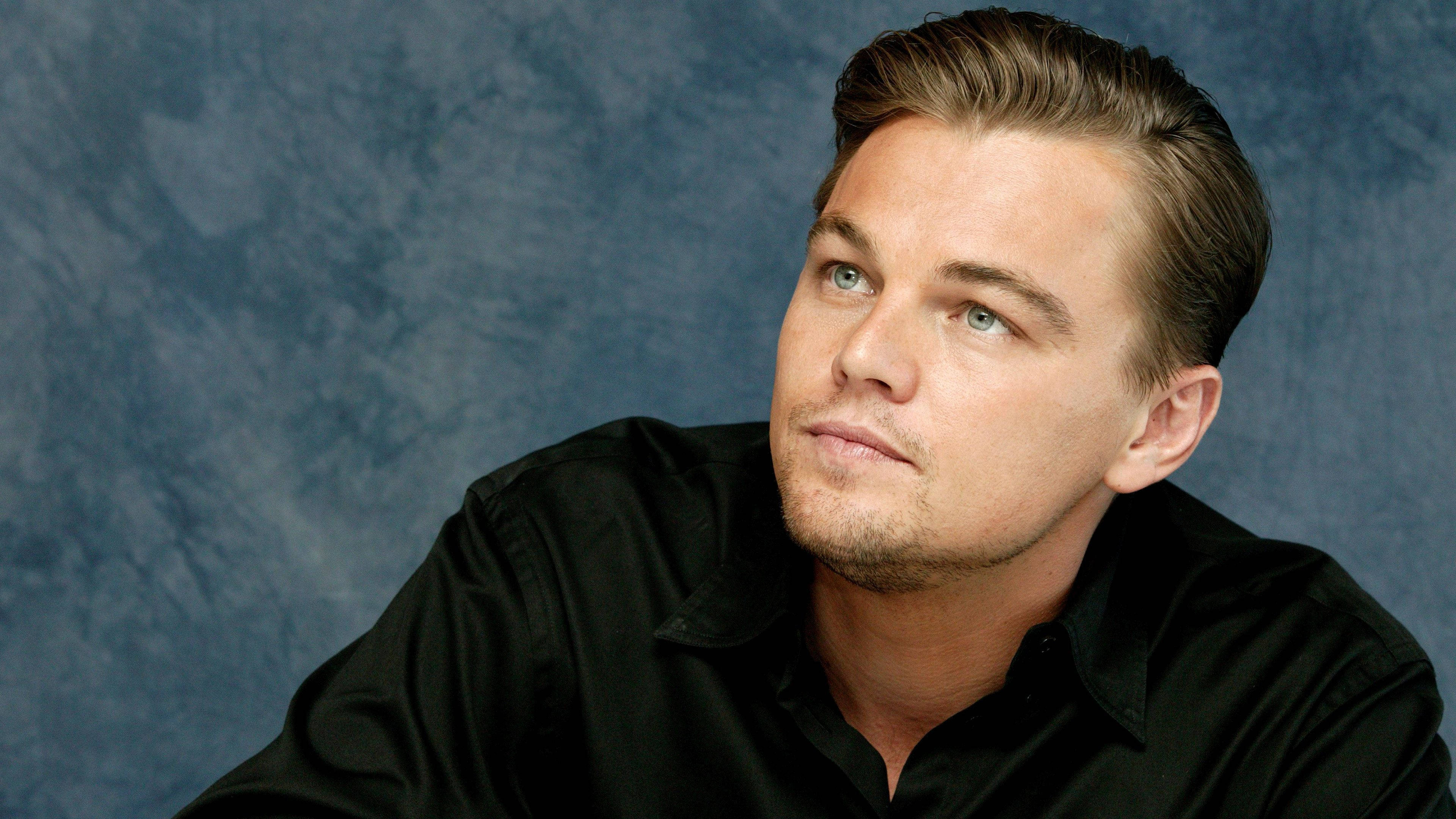 Dicaprio 桌布 壁紙 — 李奧納多狄卡皮歐在工作室肖像中，對著有紋理的藍色背景若有所思地向上凝視。