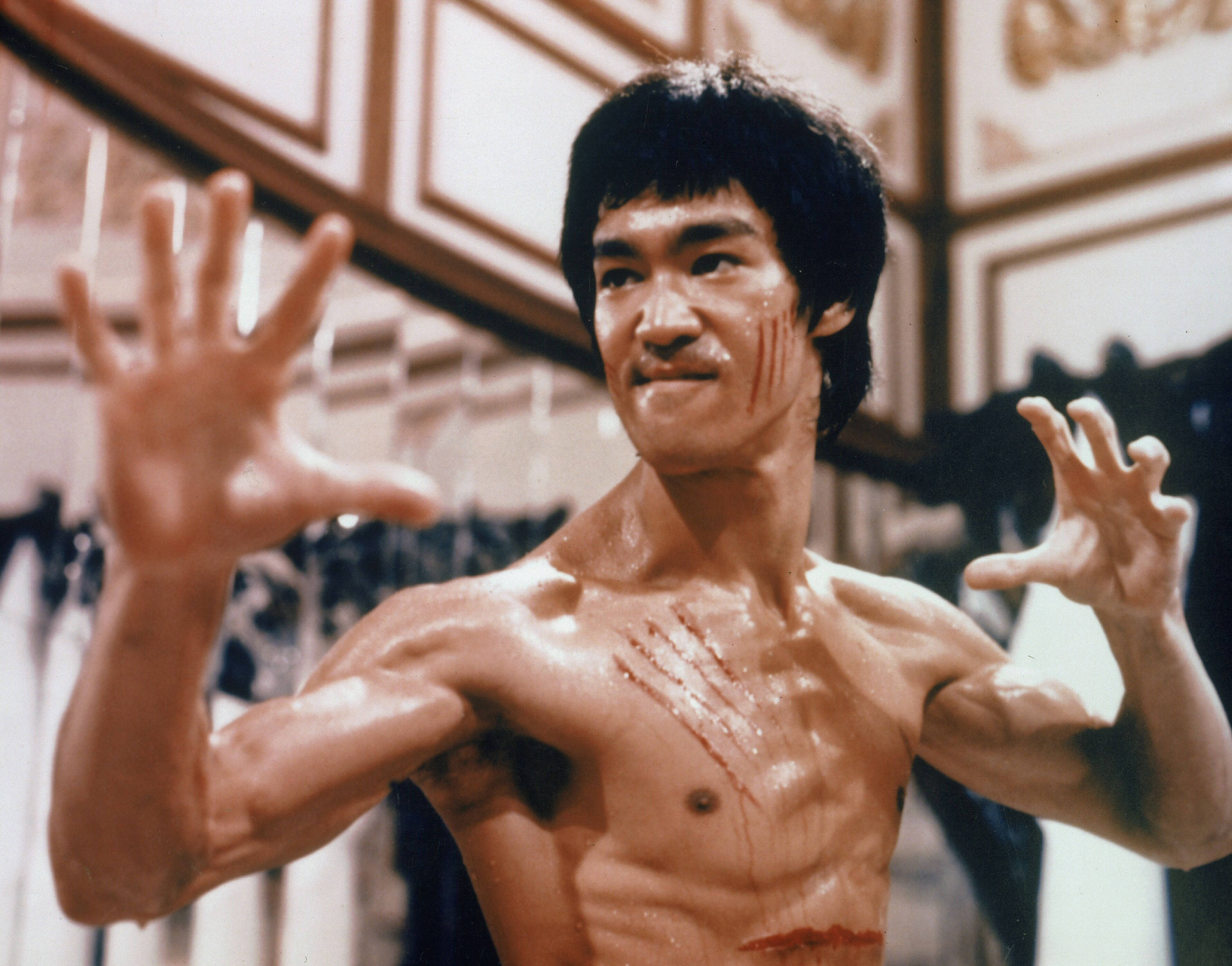李小龍 桌布 壁紙 — 李小龍在 gritty 的武術場景中，臉上和胸口有血，雙臂張開擺出戰鬥姿勢。
