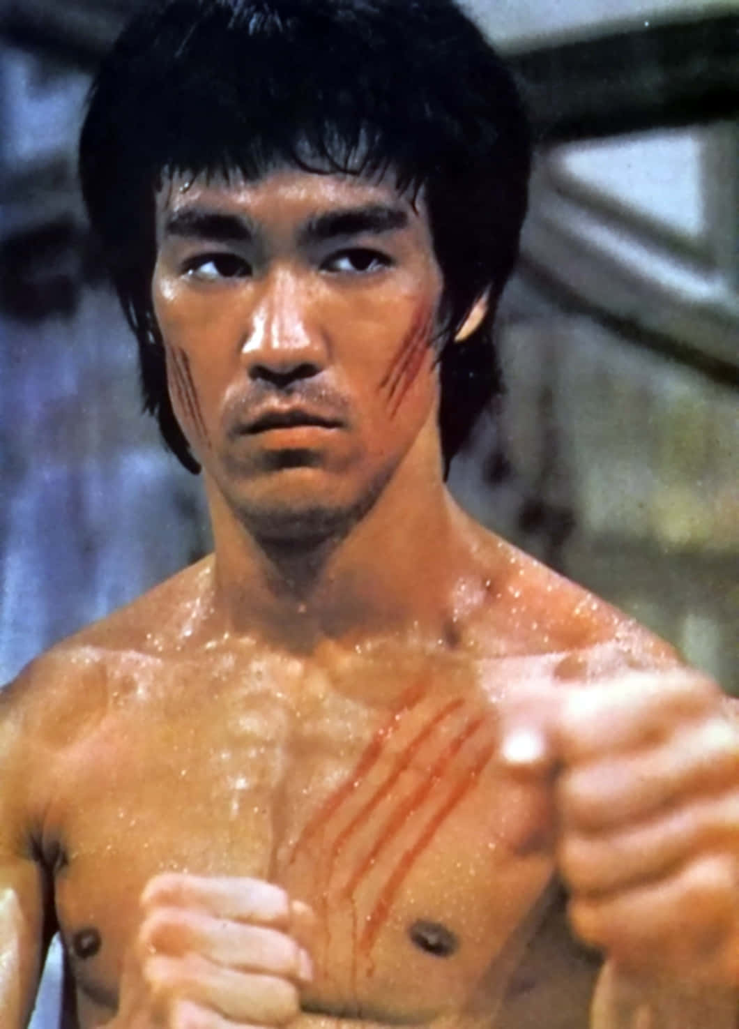 李小龍 桌布 壁紙 — 李小龍臉上和胸口帶有血痕，在 gritty 特寫鏡頭中凝視著。