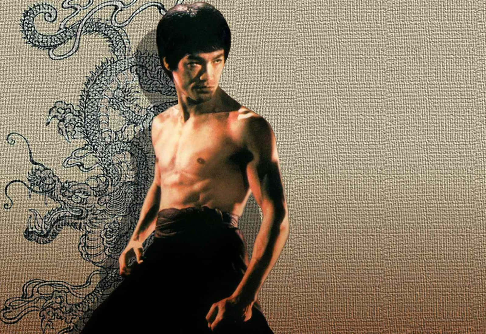 李小龍 桌布 壁紙 — 李小龍赤裸上身，以武術姿勢站在有紋理的牆前，身後有一幅黑色水墨龍壁畫。