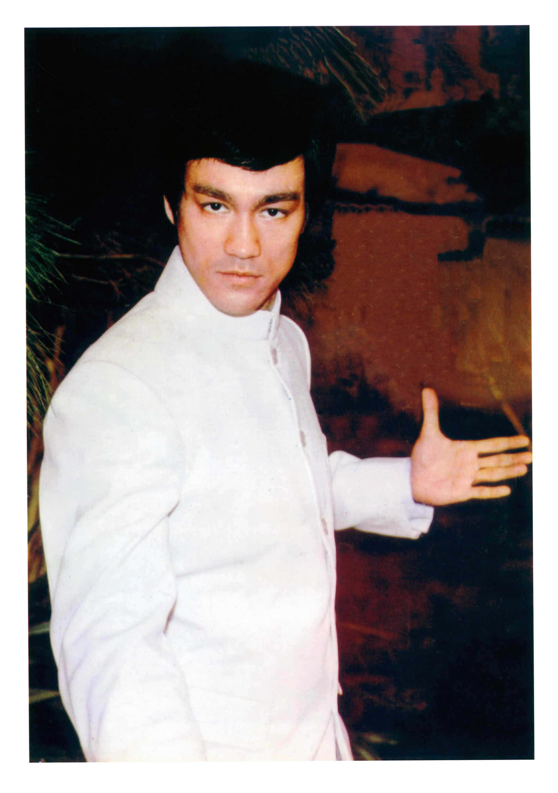 李小龍 桌布 壁紙 — 李小龍身穿白色武術服，在深色紋理背景前擺出冷靜而有力的姿勢。