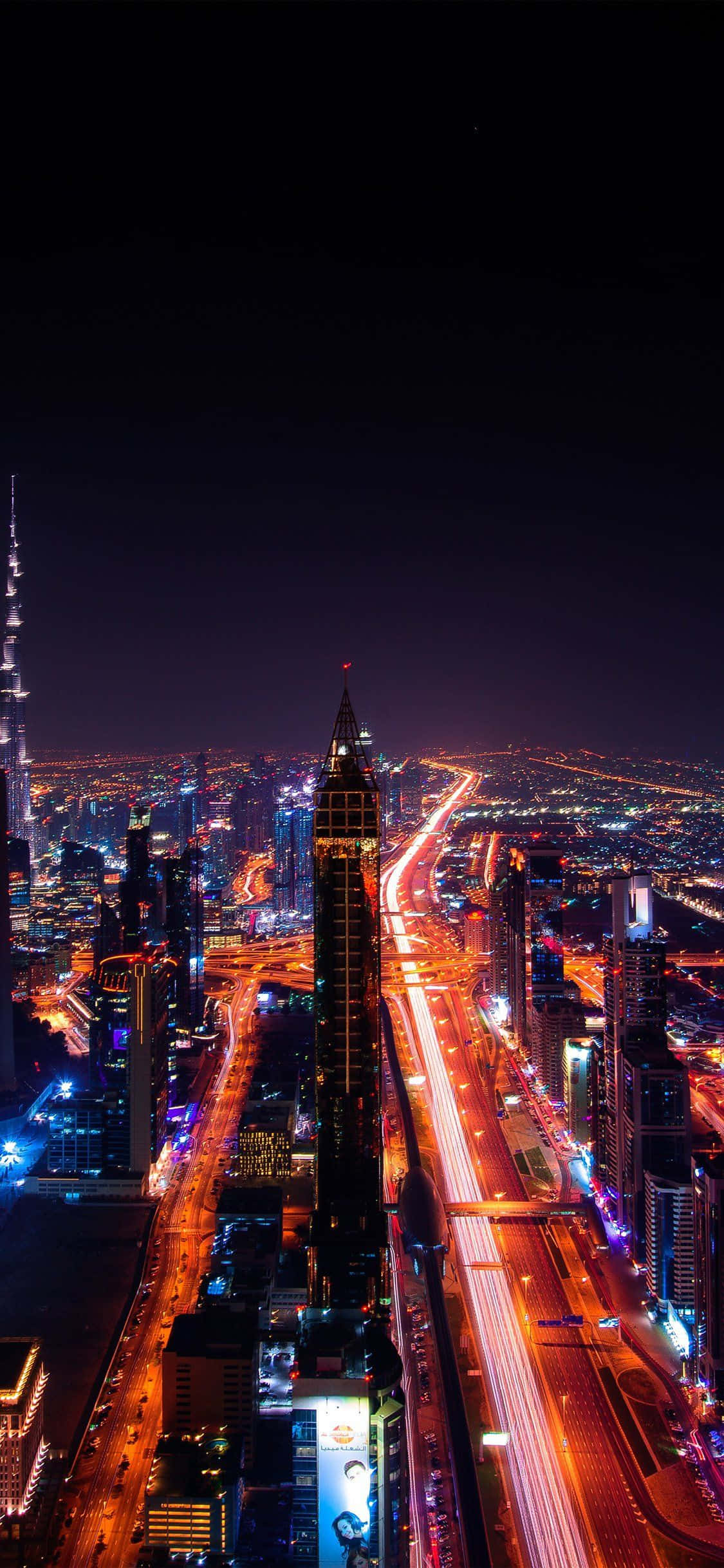 杜拜 桌布 壁紙 — 杜拜 illuminated 天際線的空中夜景，車流穿過高聳摩天大樓形成的光跡。