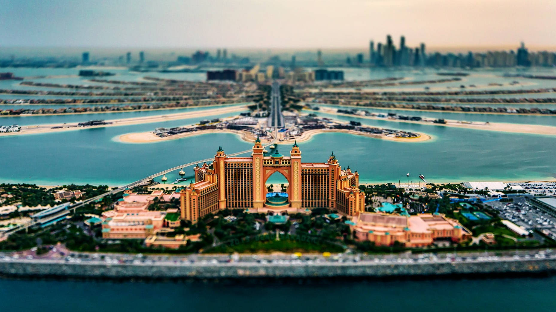 Arab 桌布 壁紙 — 杜拜亞特蘭蒂斯棕櫚酒店的驚豔移軸視角，背景是碧綠海水和朦朧城市天際線。