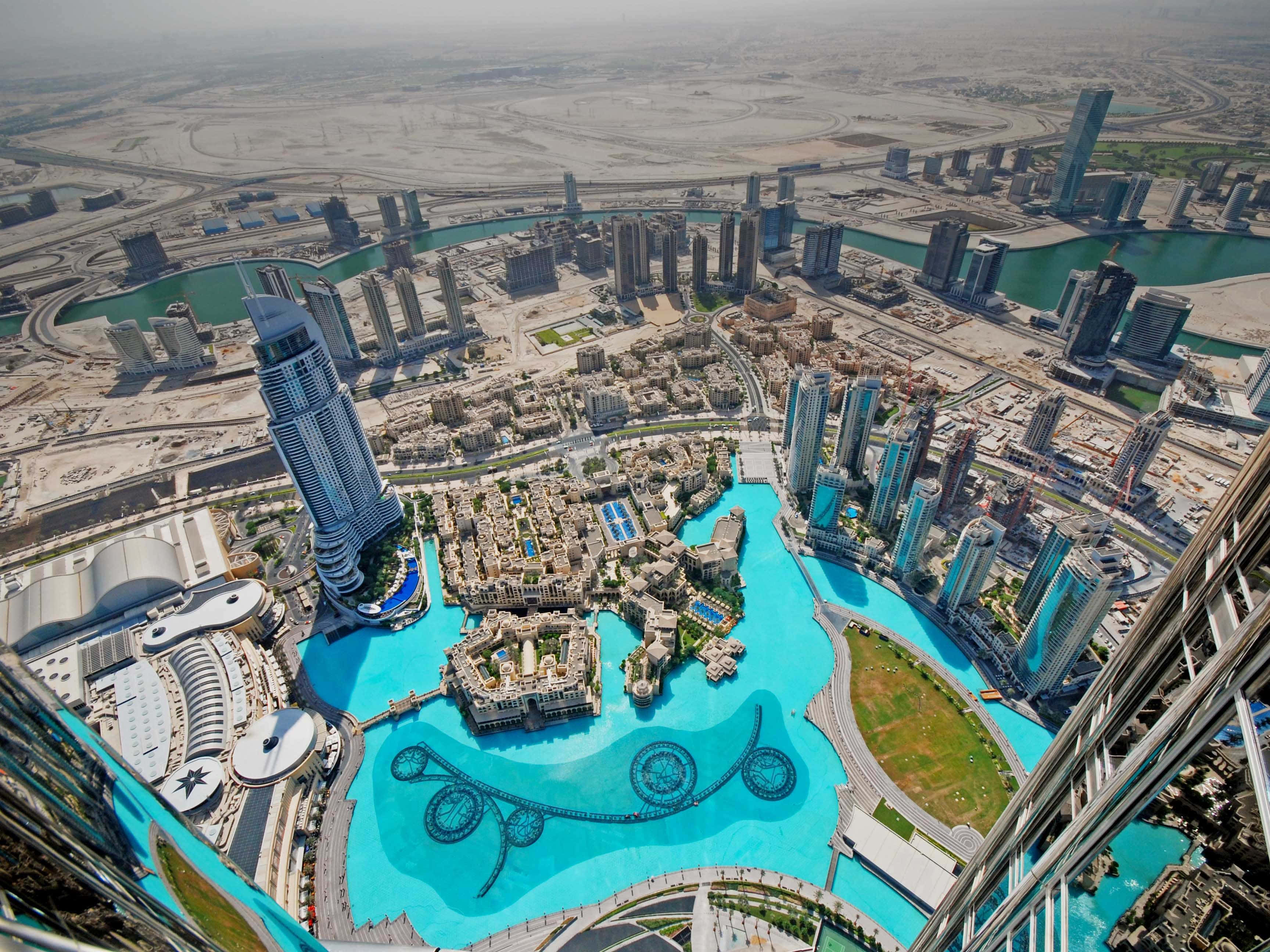 Burj Khalifa 桌布 壁紙 — 杜拜哈里發塔的航拍視圖，呈現綠松石色的人工潟湖及周圍摩天大樓在明亮日光下的景象。