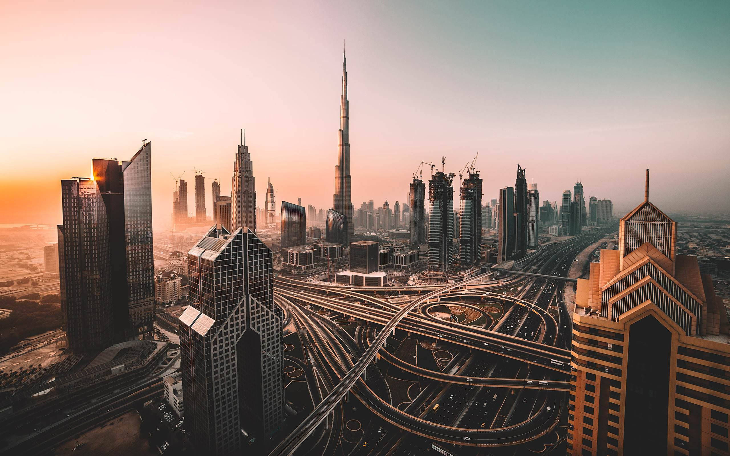 Skyscraper 桌布 壁紙 — 杜拜天際線在日落時的鳥瞰圖，哈里發塔聳立在複雜的高速公路網絡和現代摩天大樓之上。