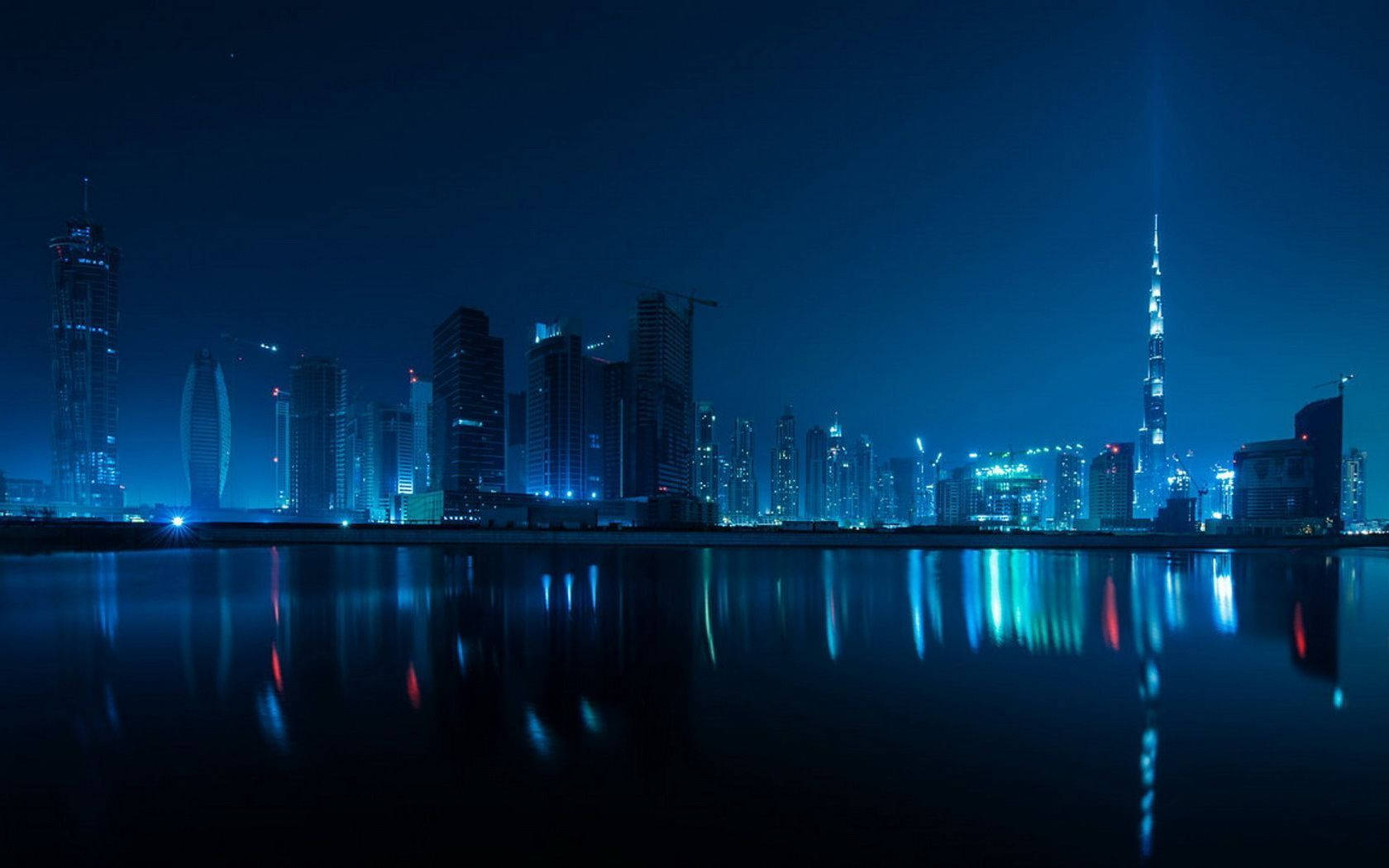 Blue Aesthetic Desktop 桌布 壁紙 — 杜拜天際線的壯麗夜景，哈里發塔閃耀並倒映在平靜的水面上。