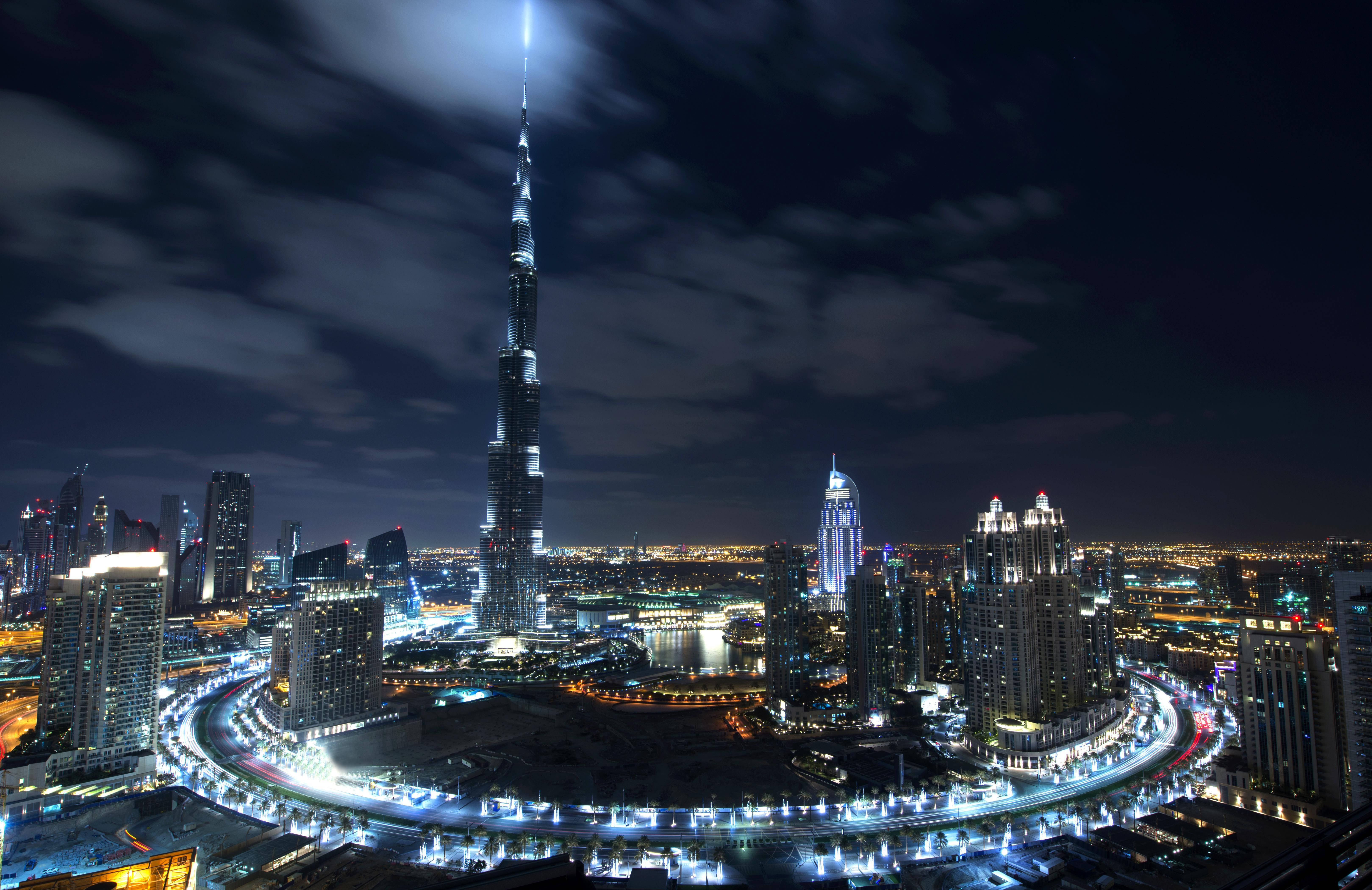 夜空 桌布 壁紙 — 杜拜天際線的迷人夜景，以照亮雲層的哈里發塔為主導。