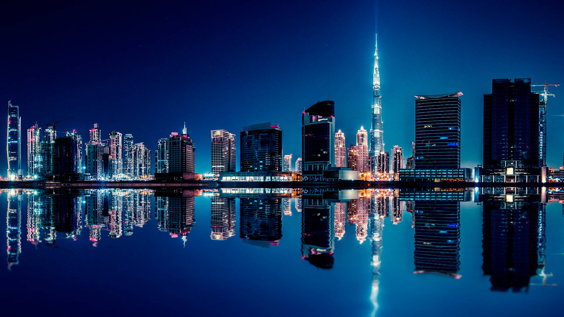 夜晚的杜拜天際線，哈利法塔倒映在水中。 — Google Meet 壁紙