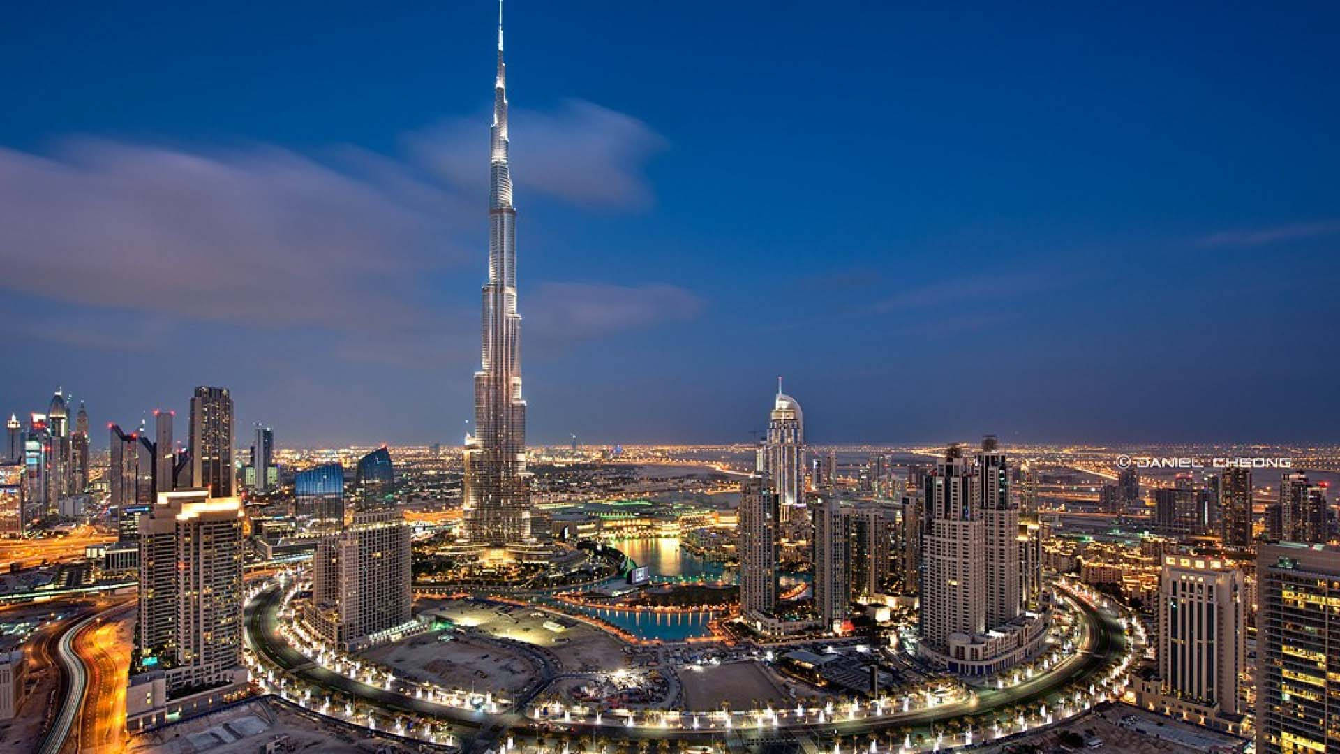 Kuwait 桌布 壁紙 — 杜拜天際線的鳥瞰圖，黃昏時分，哈里發塔聳立在燈火通明的摩天大樓和蜿蜒的道路之上。
