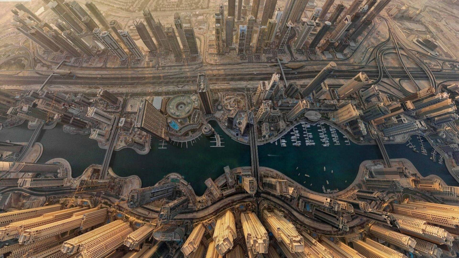 Dubai 桌布 壁紙 — 杜拜未來主義天際線的鳥瞰圖，高聳的摩天大樓環繞著一個停滿遊艇的弧形碼頭。