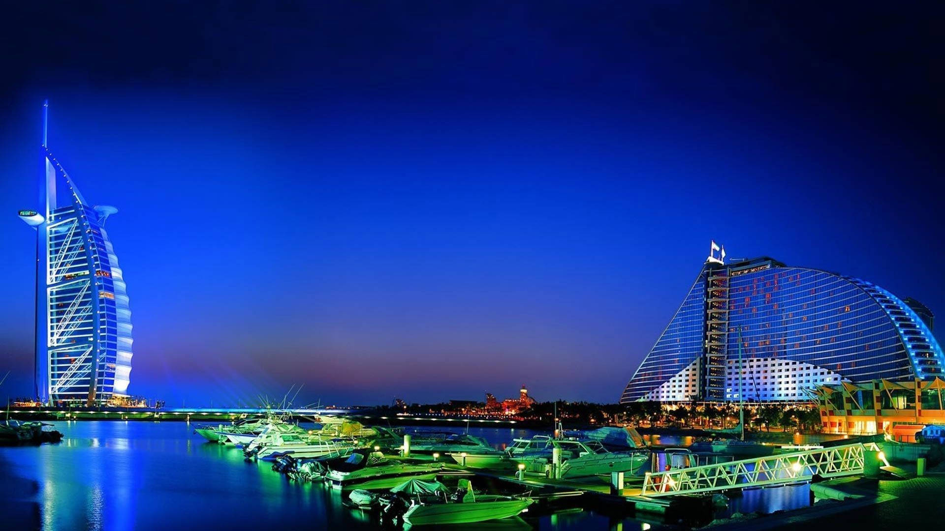 Dubai 桌布 壁紙 — 杜拜標誌性帆船飯店Burj Al Arab的迷人夜景，倒映在平靜的水面上，停泊著遊艇。