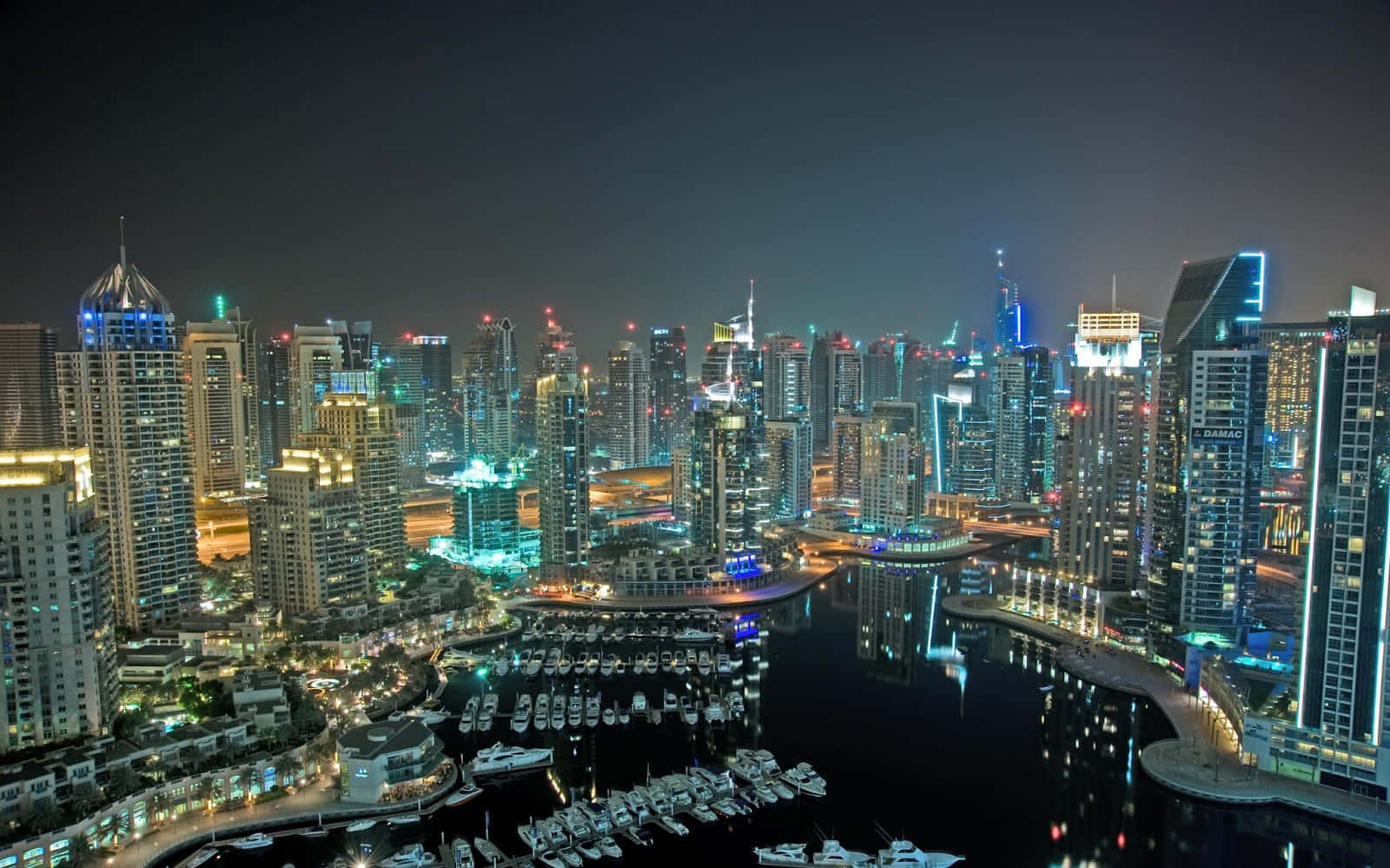 杜拜 桌布 壁紙 — 杜拜碼頭令人目眩的夜景，閃爍的摩天大樓和遊艇倒映在平靜的水面上。