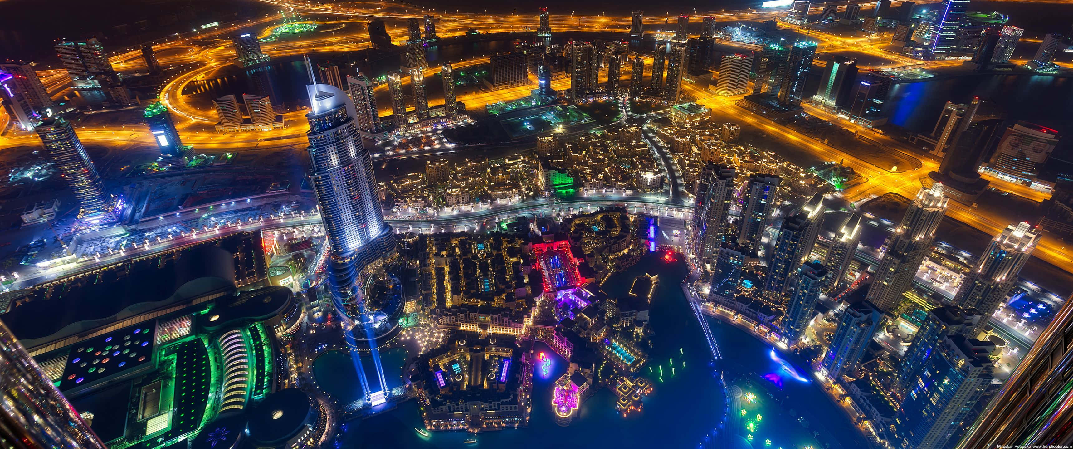 城市風景 桌布 壁紙 — 杜拜閃爍天際線的空中夜景，照亮摩天大樓和發光的道路。