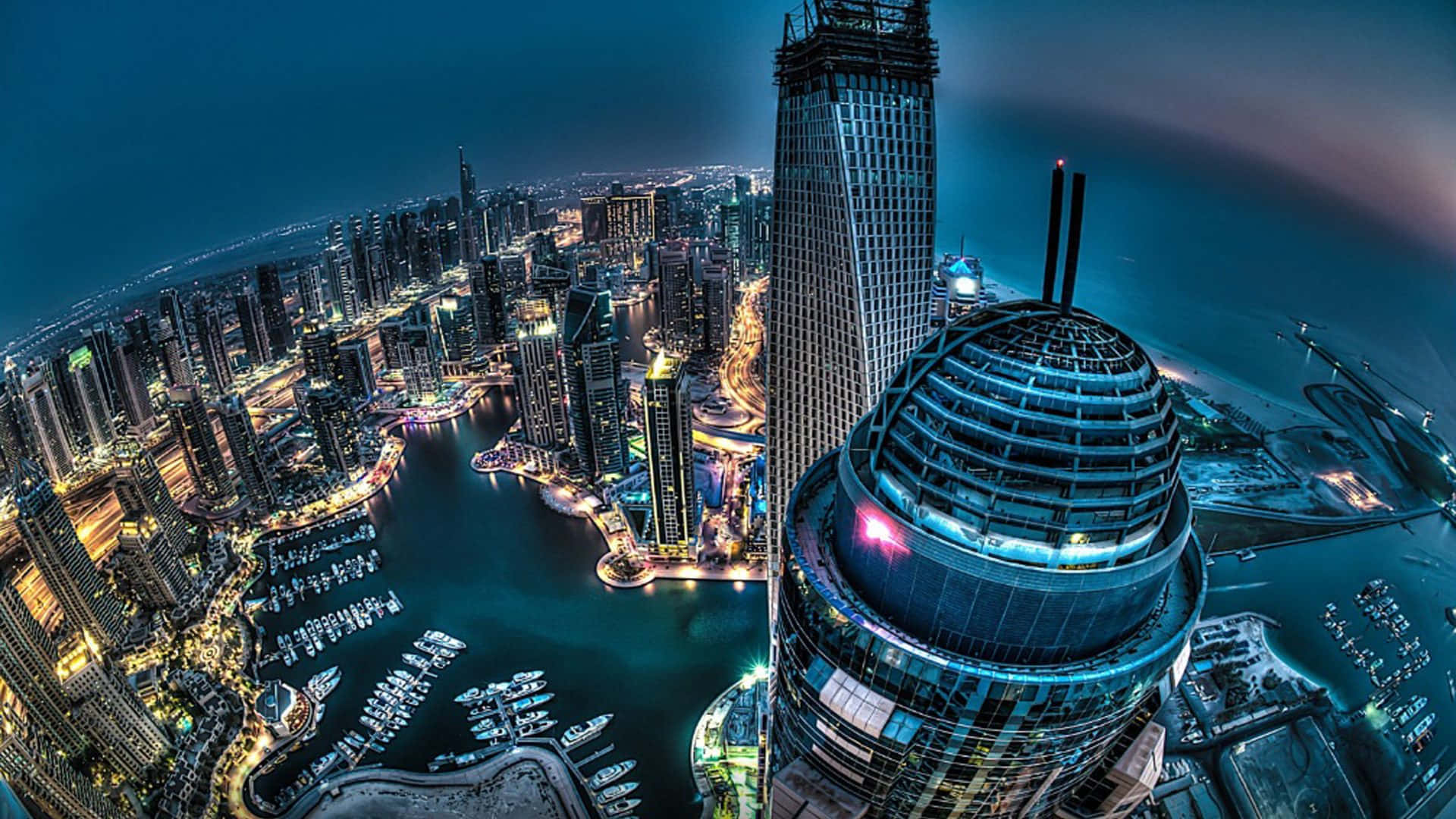 杜拜 桌布 壁紙 — 杜拜閃爍天際線的魚眼夜景，照亮摩天大樓和停滿船隻的碼頭。