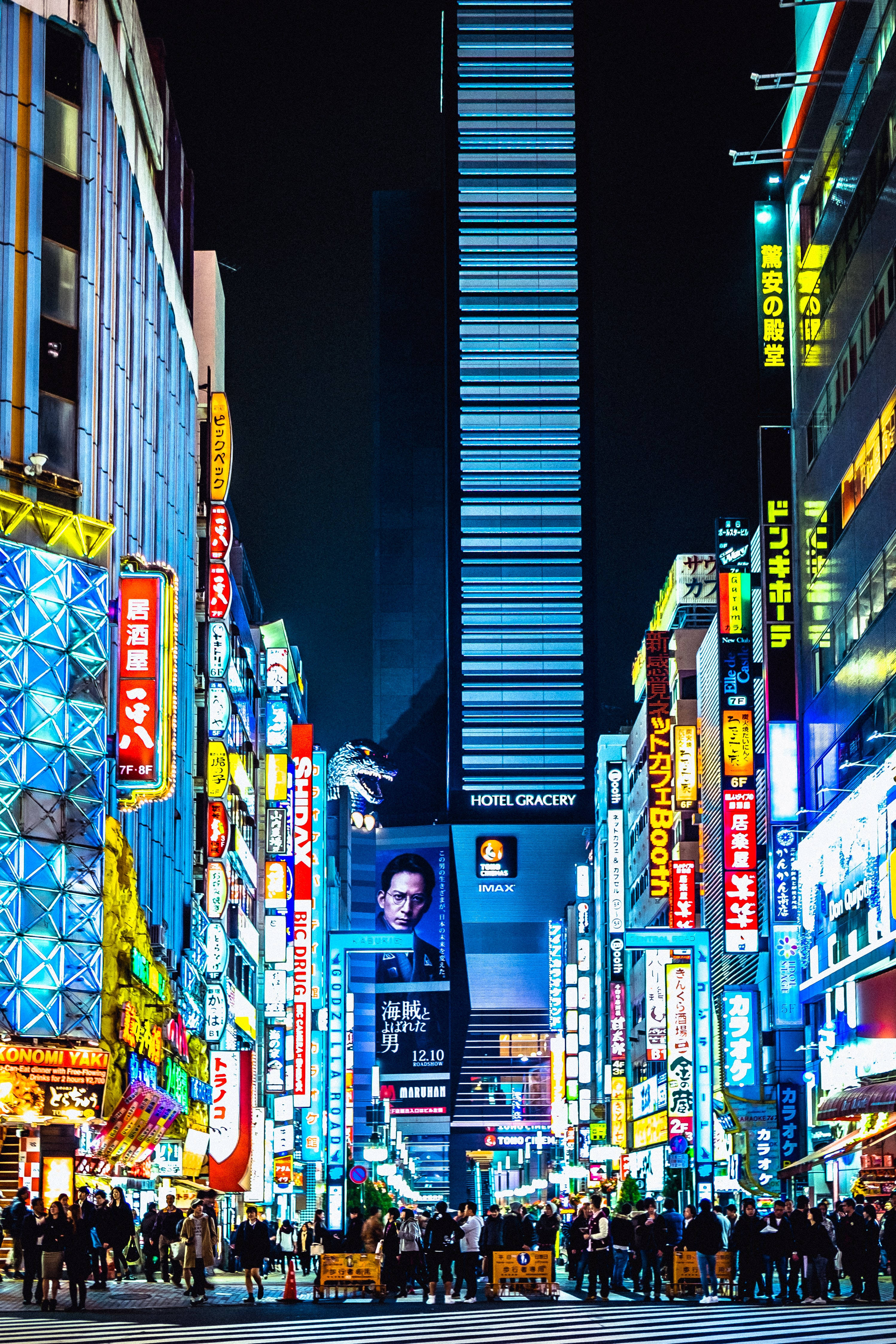 日本 桌布 壁紙 — 東京一條繁忙街道的耀眼夜景，被高聳的霓虹燈招牌和發光的廣告牌照亮。