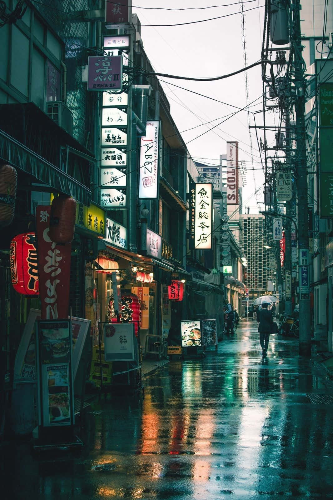 灰色美學動圖 桌布 壁紙 — 東京一條雨中的霓虹燈小巷，發光的招牌在濕漉漉的路面上反射，一個孤獨的身影正在走遠。