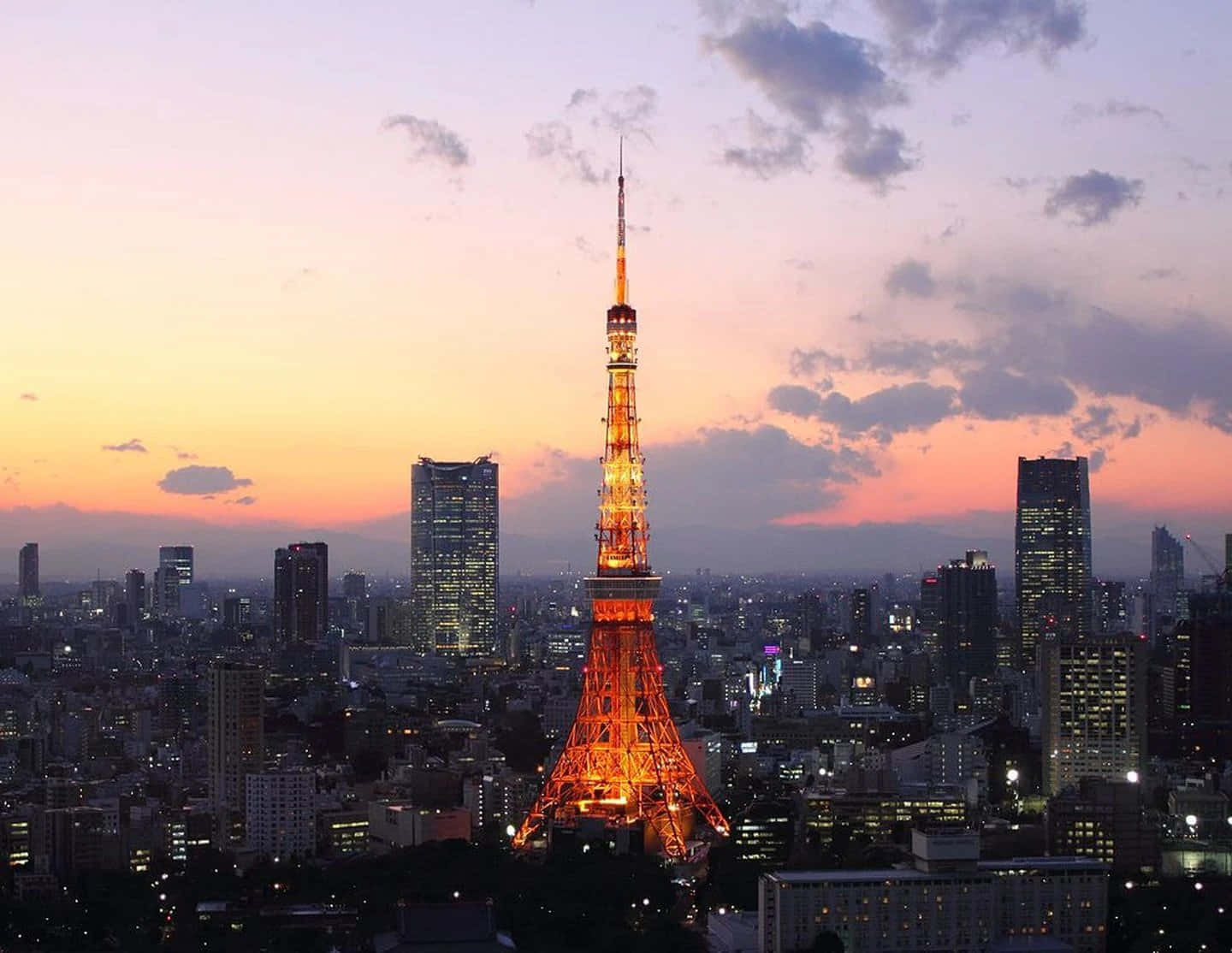 東京 桌布 壁紙 — 東京塔在暮色天空中溫暖地發光，城市燈光開始在城市天際線上閃爍。