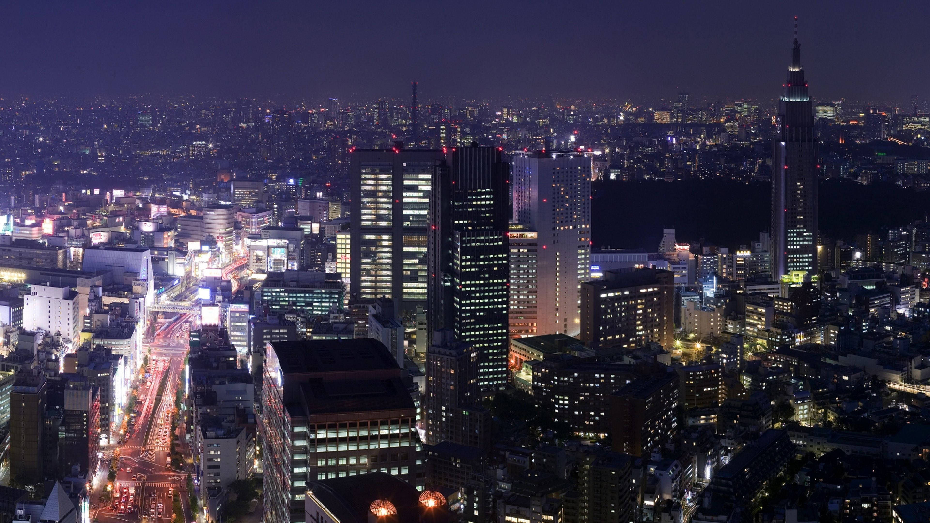 城市 桌布 壁紙 — 東京夜晚的鳥瞰圖，閃爍的摩天大樓和流動的城市燈光照亮了城市擴張。