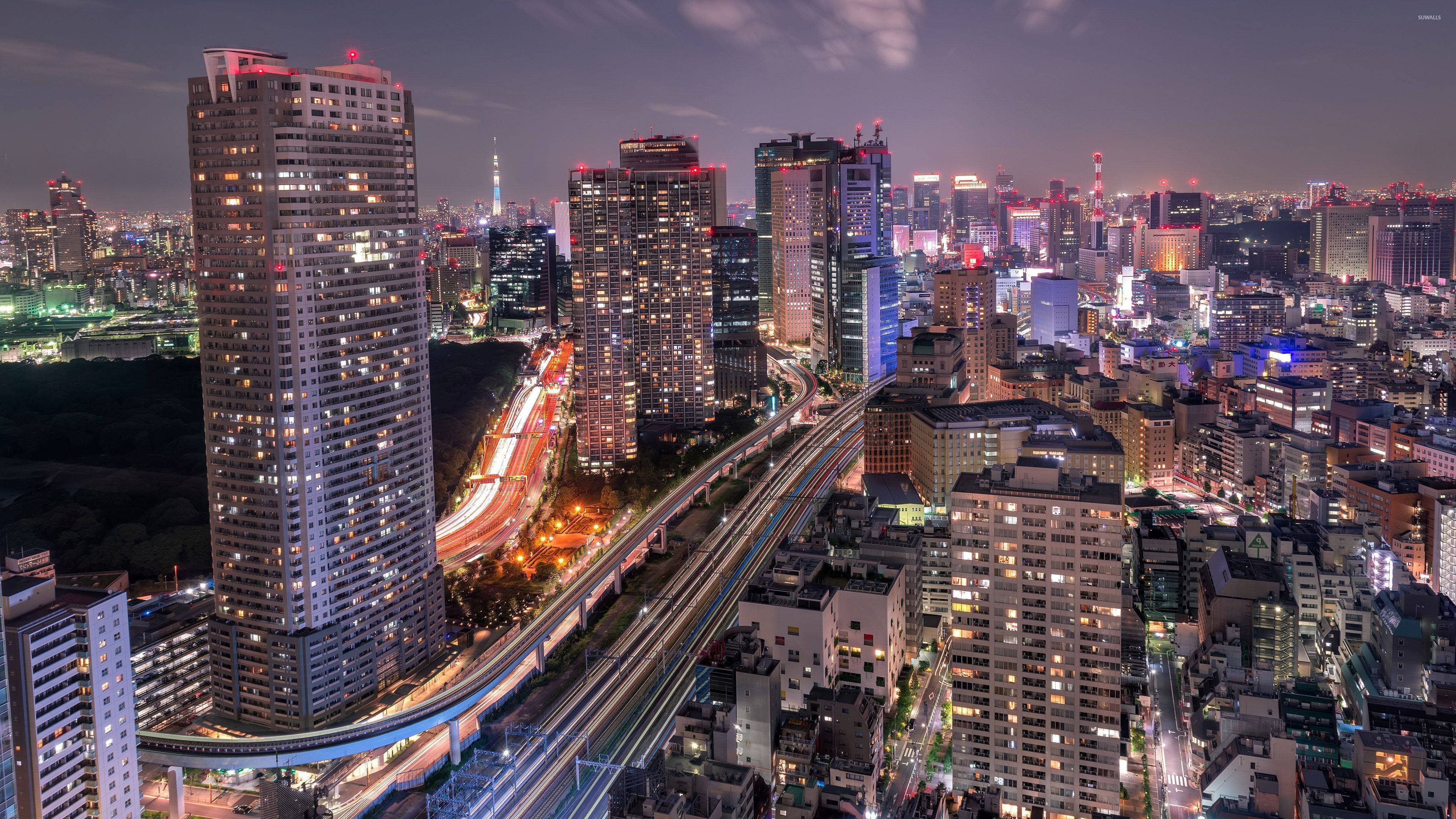 東京 桌布 壁紙 — 東京夜景鳥瞰圖，閃爍的摩天大樓和繁忙高速公路上的光跡。