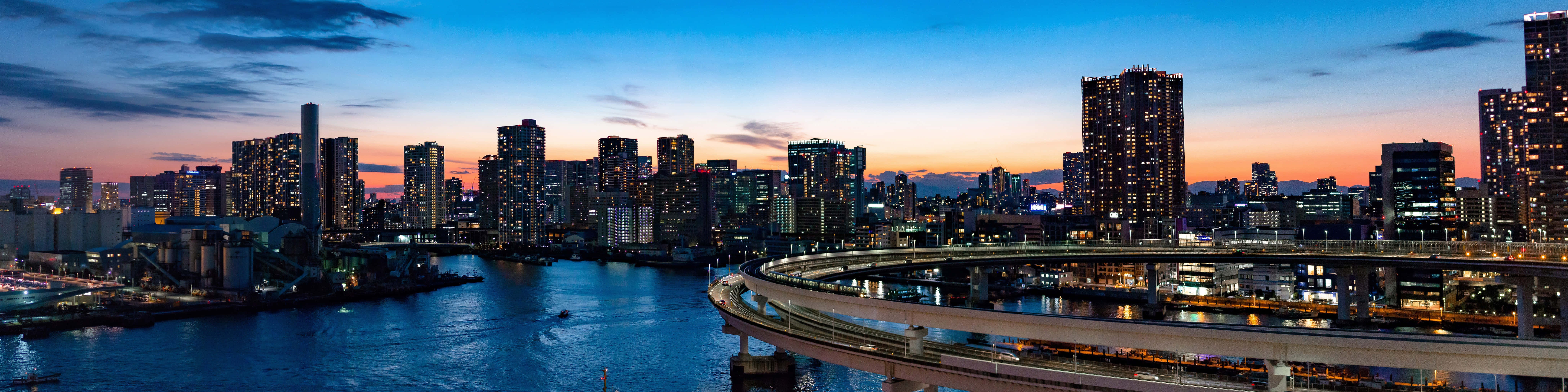 高清 桌布 壁紙 — 東京天際線的黃昏全景，發光的摩天大樓和彎曲的高速公路倒映在河中。