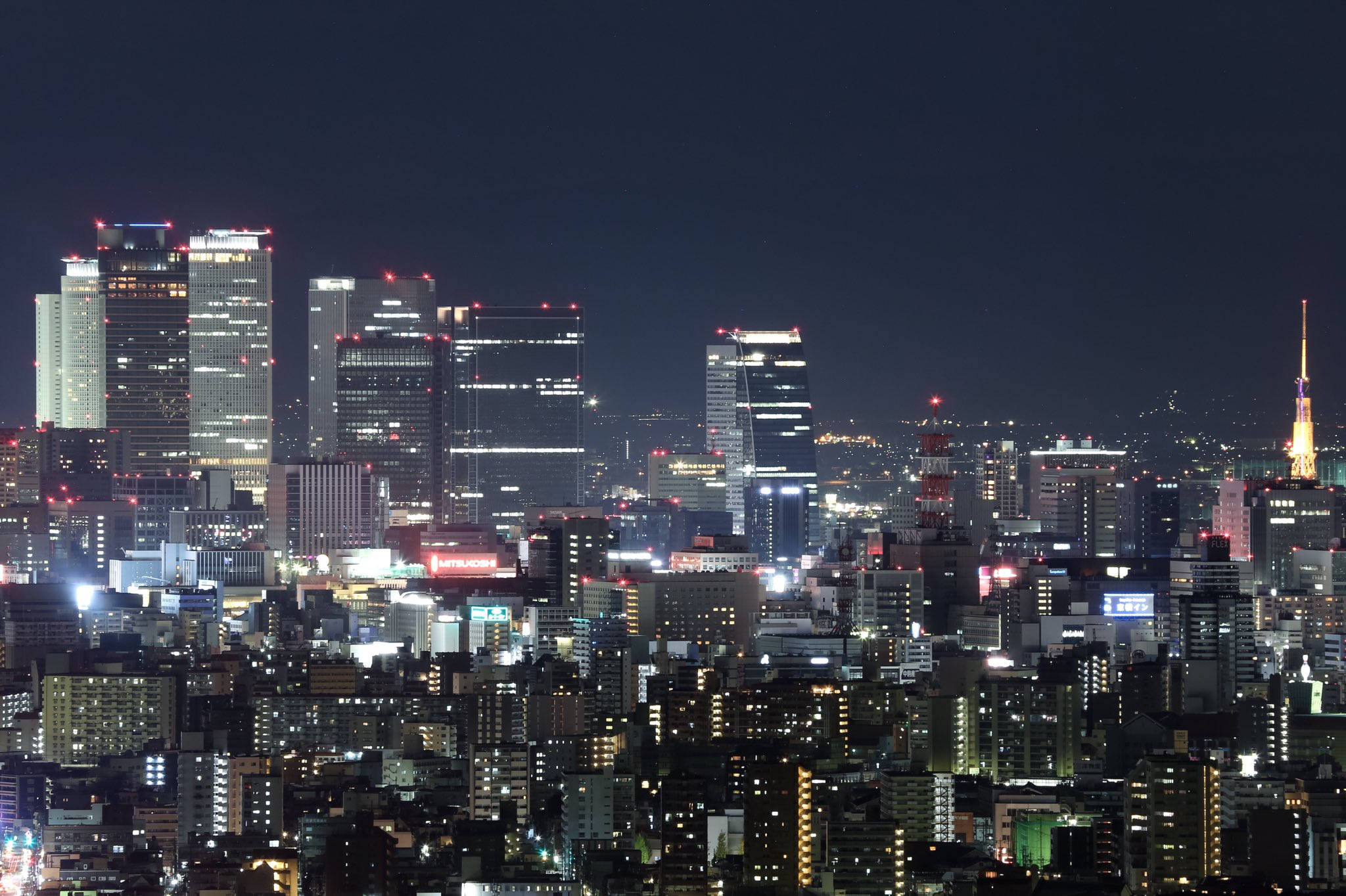 Nagoya 桌布 壁紙 — 東京廣闊的夜景，摩天大樓閃爍，密集的城市燈光在黑暗的天空下。