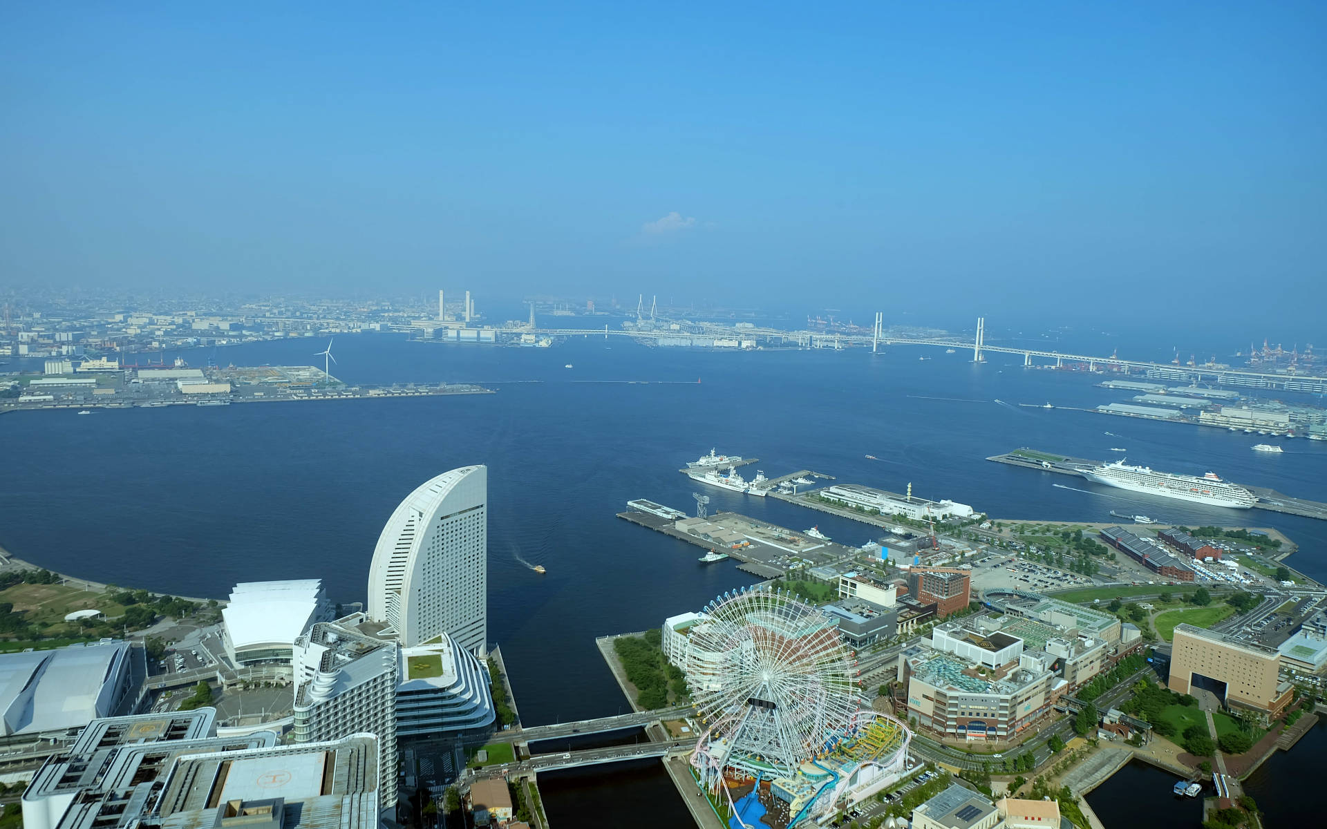 Yokohama 桌布 壁紙 — 東京灣的鳥瞰圖，有郵輪碼頭、色彩繽紛的摩天輪和現代建築，在晴朗的藍天下。