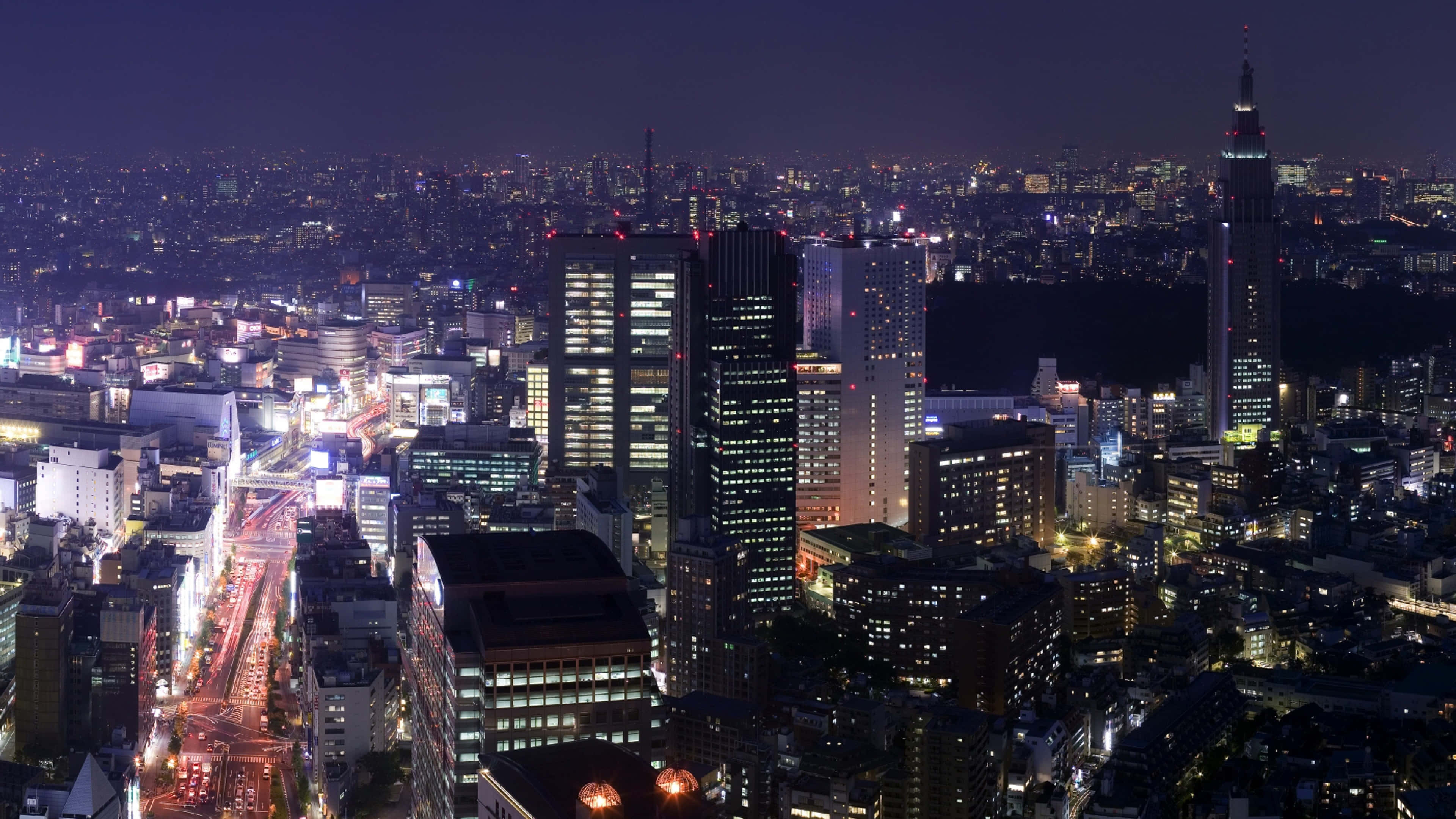 City Night 桌布 壁紙 — 東京璀璨天際線的夜間空中景觀，下方是發光的摩天大樓和繁忙的街道。