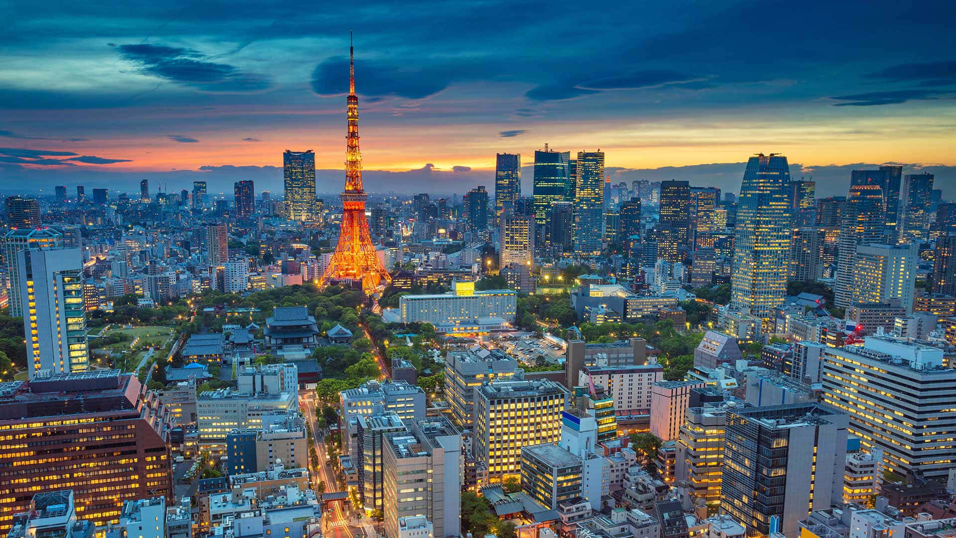 天際線 桌布 壁紙 — 東京鐵塔在暮色中溫暖地發光，城市的燈光照亮了下方廣闊的大都市。