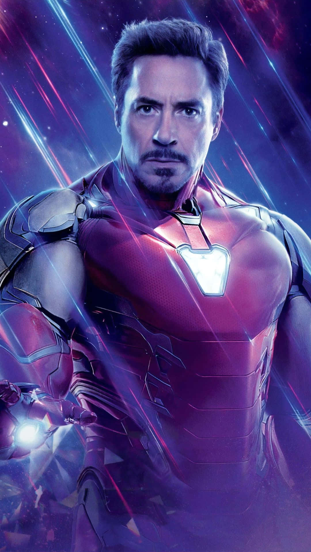 Android Iron Man 桌布 壁紙 — 東尼·史塔克穿著紅色和金色的鋼鐵人戰衣，站在宇宙紫色和藍色能量條紋前，發光的弧形反應器閃耀。