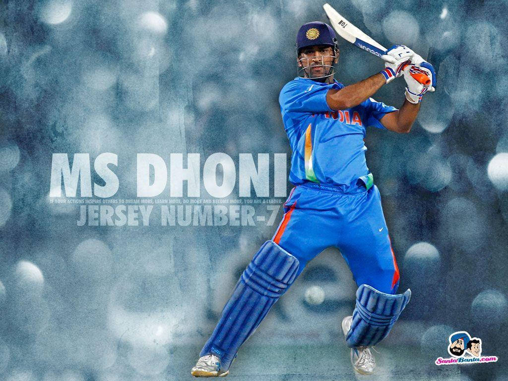 Ms Dhoni 桌布 壁紙 — 板球傳奇 MS Dhoni 身穿藍色印度隊服，在模糊的體育場背景和發光球體中揮棒。