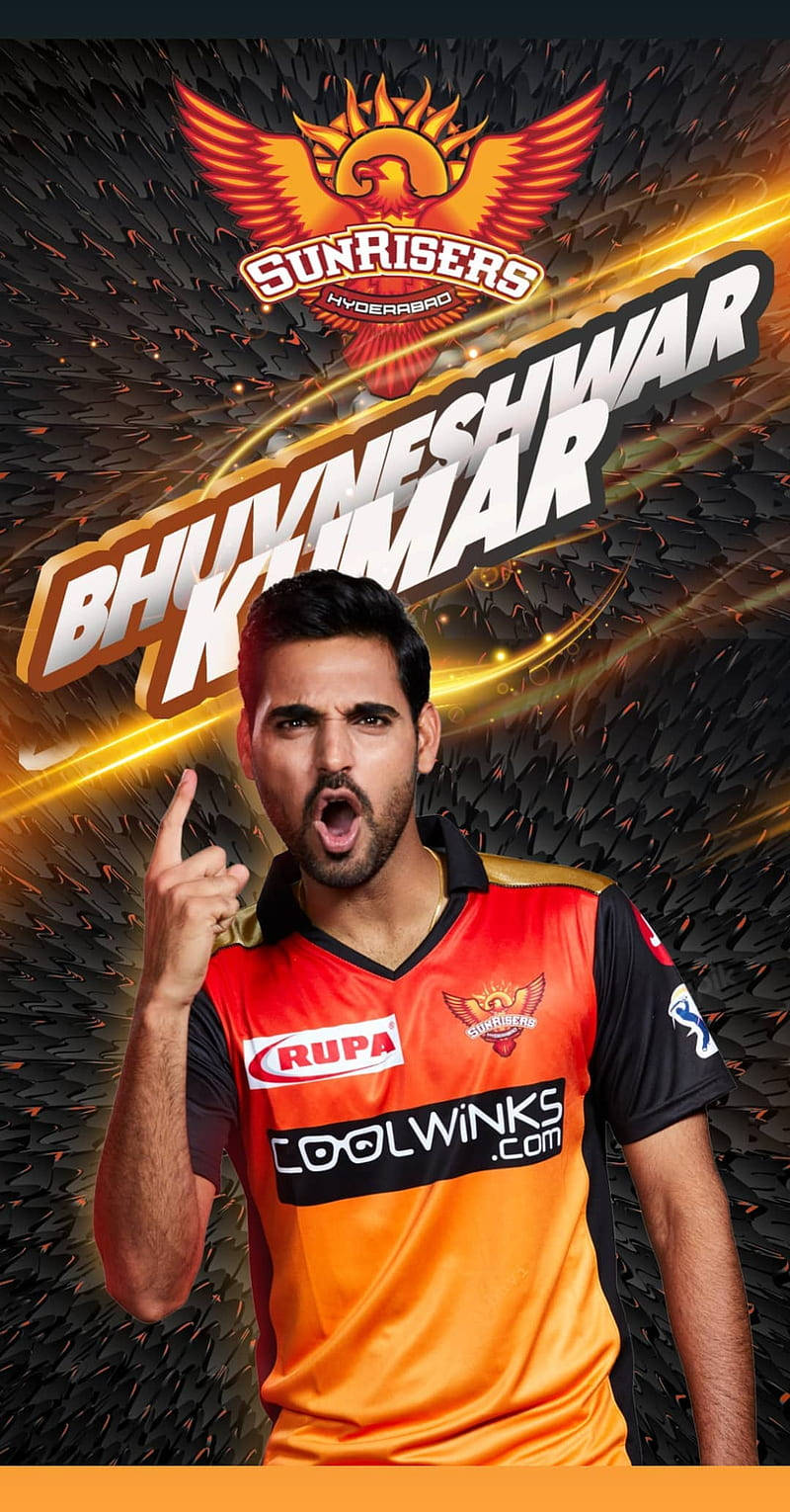Sunrisers Hyderabad 桌布 壁紙 — 板球運動員 Bhuvneshwar Kumar 身穿 Sunrisers Hyderabad 球衣，在熾熱的金色和黑色紋理背景上向上指。
