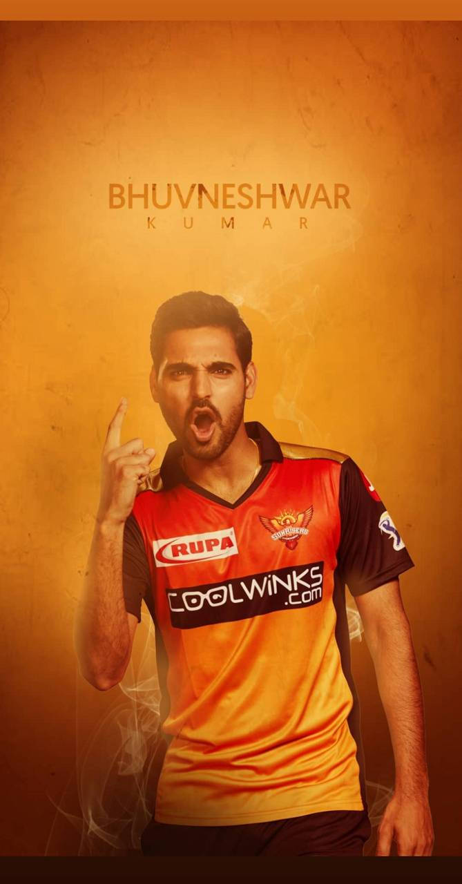 Sunrisers Hyderabad 桌布 壁紙 — 板球運動員 Bhuvneshwar Kumar 身穿橙色球衣，在紋理金色背景前舉起手指大喊。