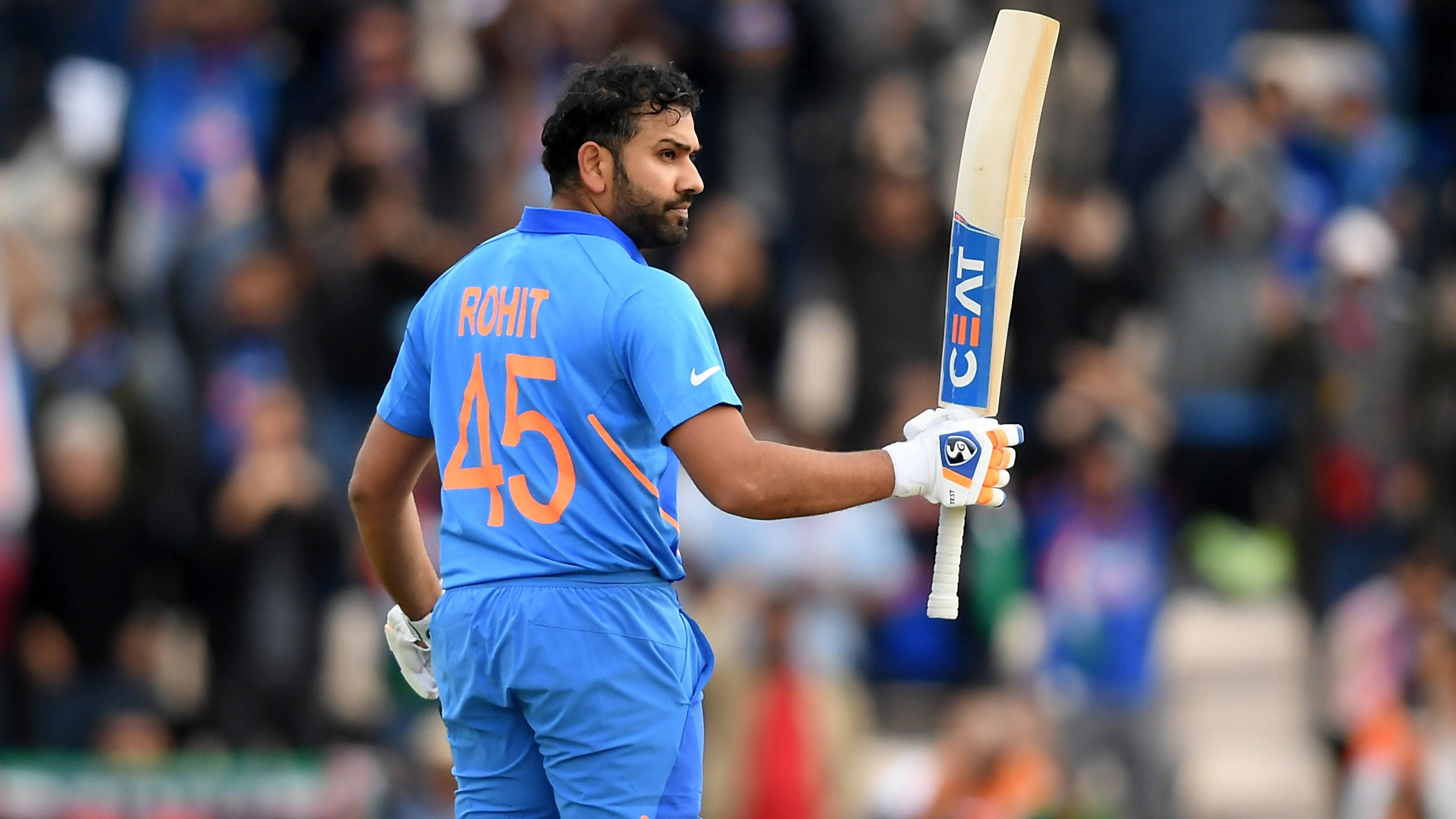 Rohit Sharma 桌布 壁紙 — 板球運動員 Rohit Sharma 身穿藍色45號球衣，手持球棒，從體育場人群中走開。