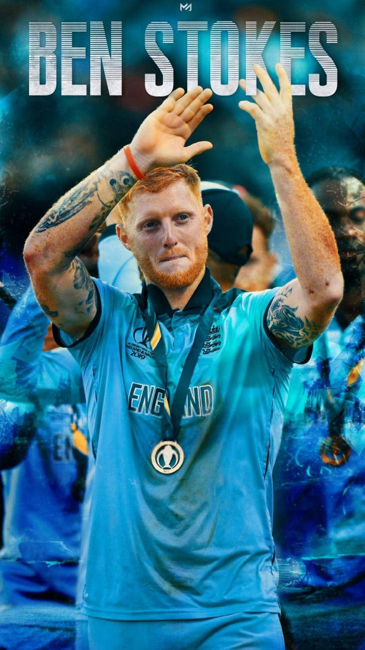 England Cricket 桌布 壁紙 — 板球運動員班·斯托克斯身穿藍色英格蘭球衣，在模糊的人群背景下舉手慶祝勝利，紋身清晰可見。
