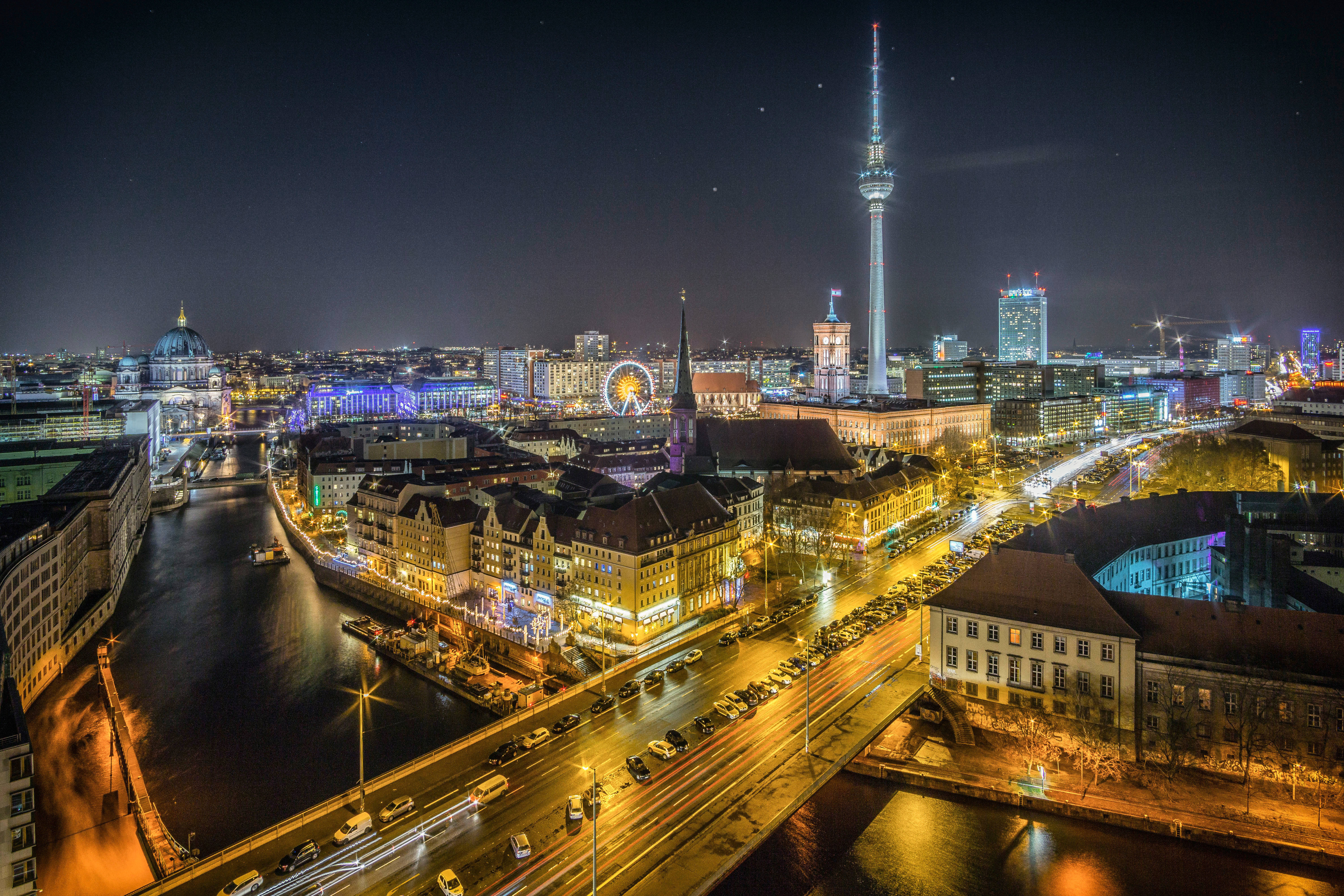 Berlin 桌布 壁紙 — 柏林充滿活力的夜空，沿著施普雷河閃耀著金色的路燈和霓虹色調。
