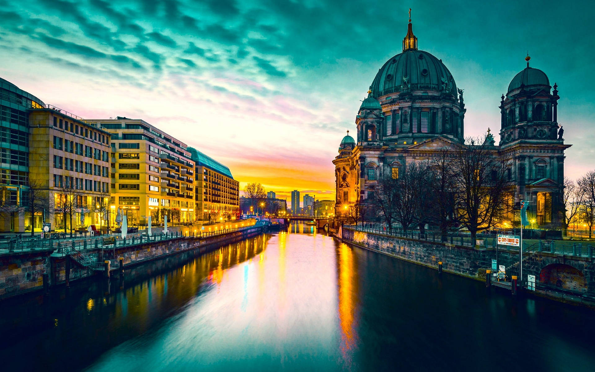 Berlin 桌布 壁紙 — 柏林大教堂在黃昏時分巍然聳立，其圓頂在平靜的施普雷河映照下，閃耀著充滿活力的青綠色和橙色天空。