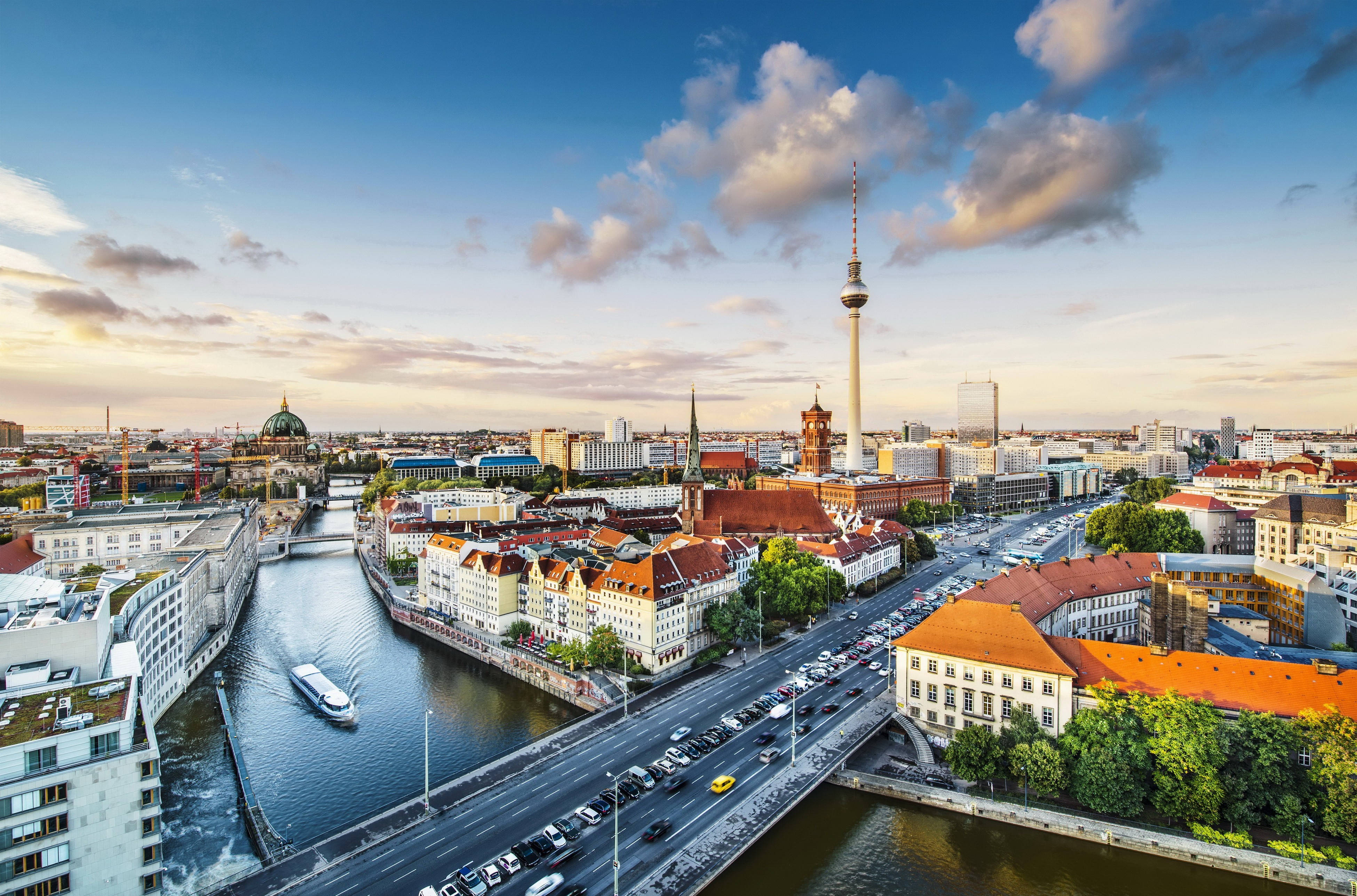 Berlin 桌布 壁紙 — 柏林日落時分的鳥瞰圖，展示電視塔、河流橋樑和歷史建築，在金色雲彩下。