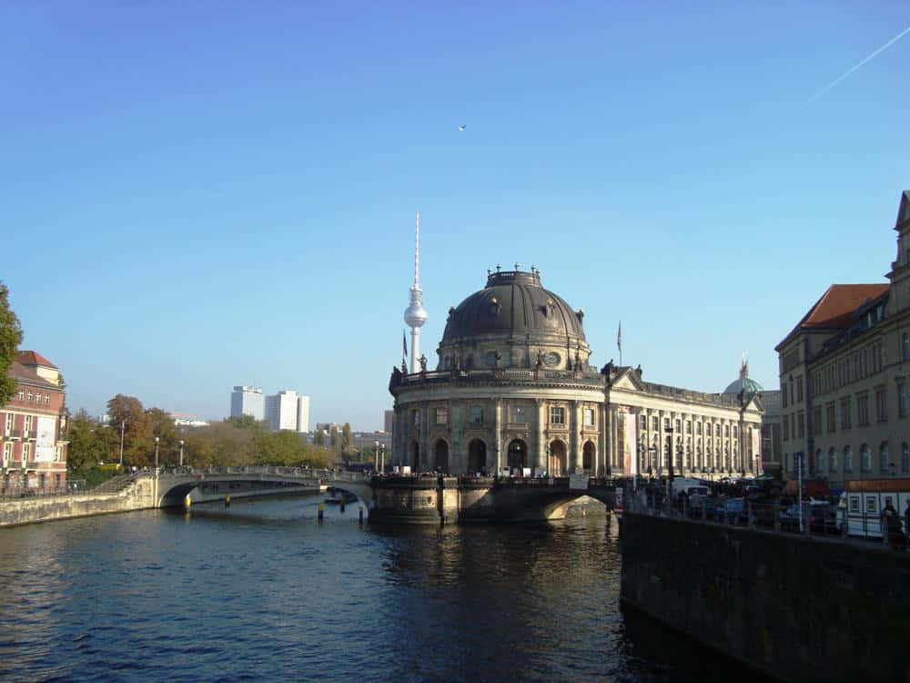 Berlin 桌布 壁紙 — 柏林的國會大廈以其標誌性圓頂和電視塔，在晴朗的藍天下雄偉地矗立在施普雷河畔。