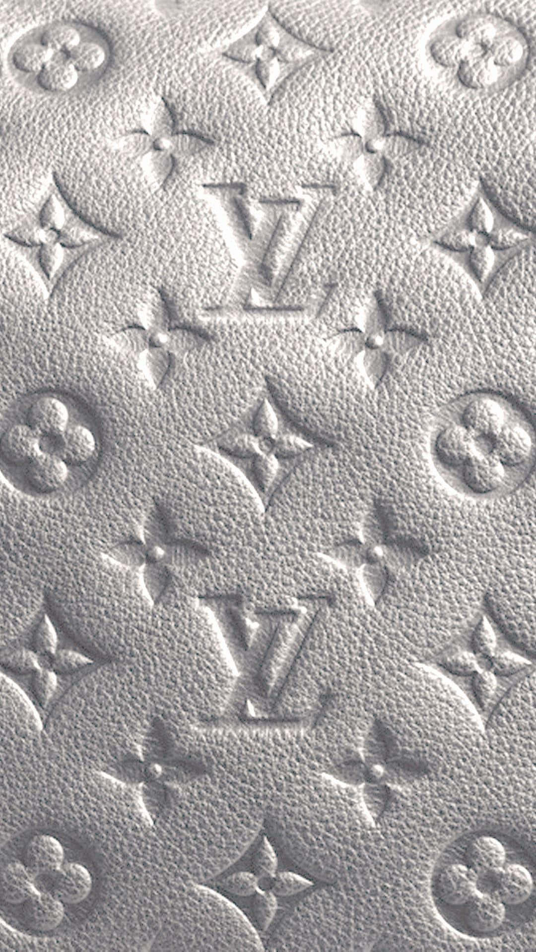 Louis Vuitton Logo 桌布 壁紙 — 柔光下帶有浮雕路易威登字母組合和花卉圖案的紋理白色皮革特寫。