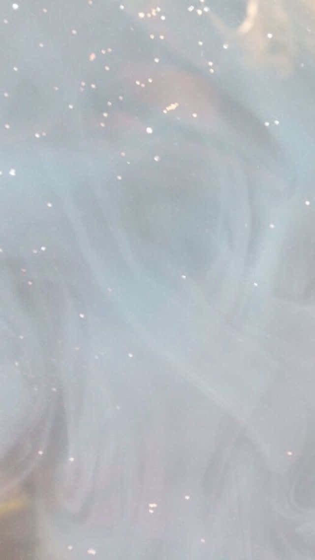 White Glitter 桌布 壁紙 — 柔和旋轉的淺藍色和白色煙霧，帶有散落的金色亮粉顆粒，營造出夢幻空靈的效果。