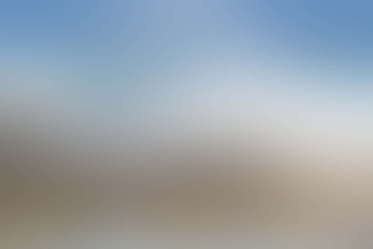 Blurry 桌布 壁紙 — 柔和漸變天空從淡藍色過渡到溫暖的米色，營造出寧靜簡約的背景。