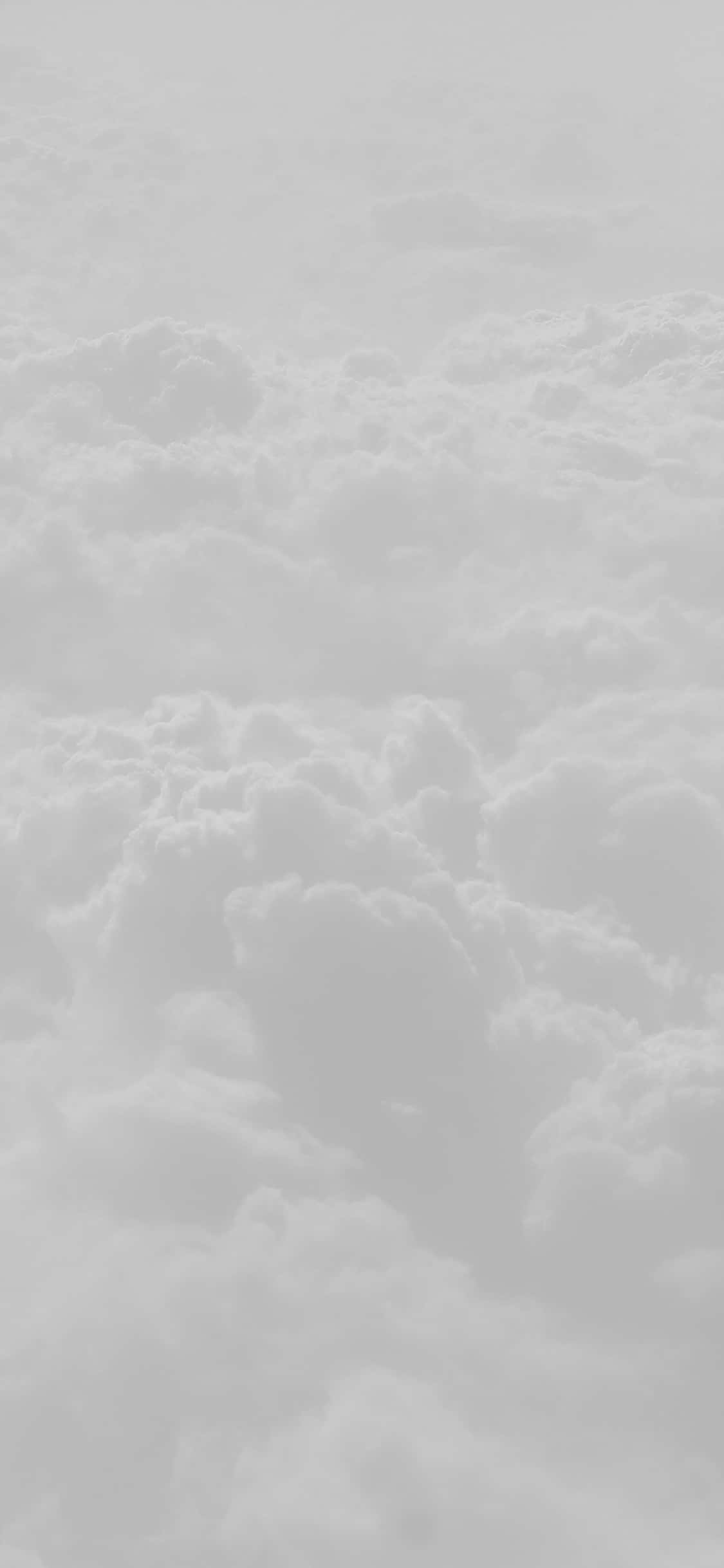 White Clouds 桌布 壁紙 — 柔和灰色天空中無盡延伸的蓬鬆雲朵的寧靜單色景象。