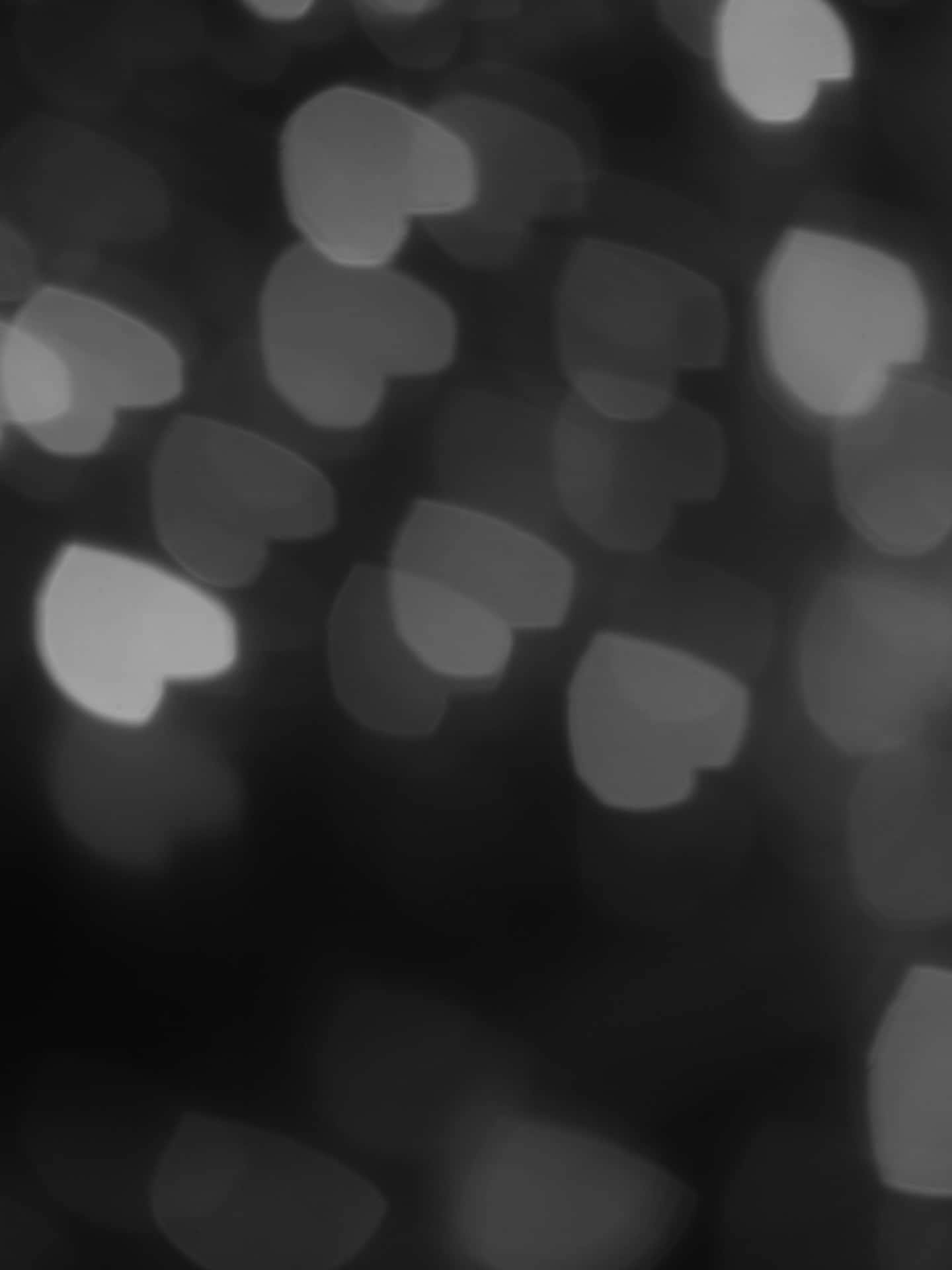 Aesthetic Black Heart 桌布 壁紙 — 柔和灰階散景心形在深色背景上輕輕發光，營造夢幻浪漫的氛圍。