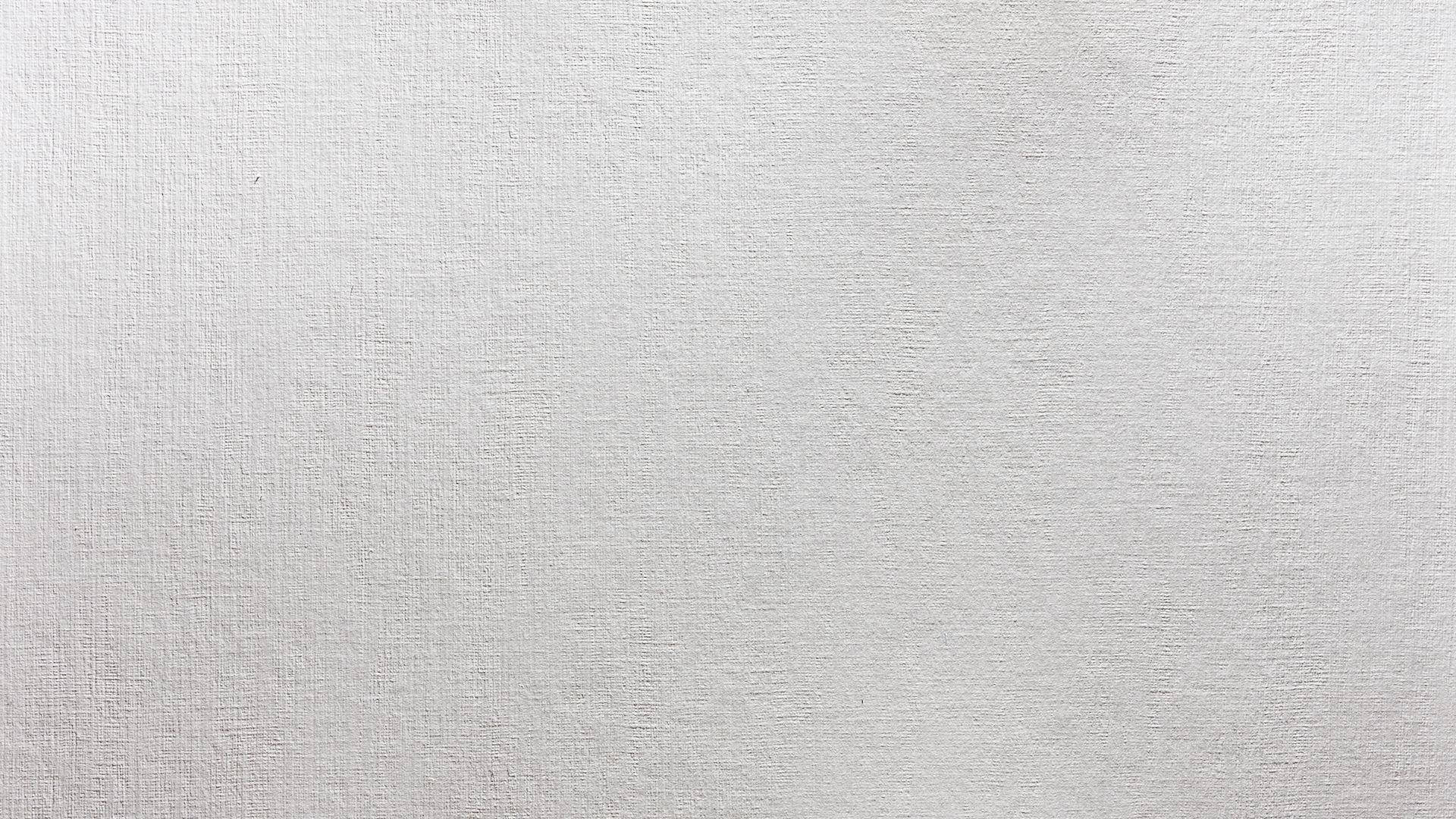 White Texture 桌布 壁紙 — 柔和燈光下，光滑白色紋理牆壁的微距特寫，帶有細微的布料般編織圖案。